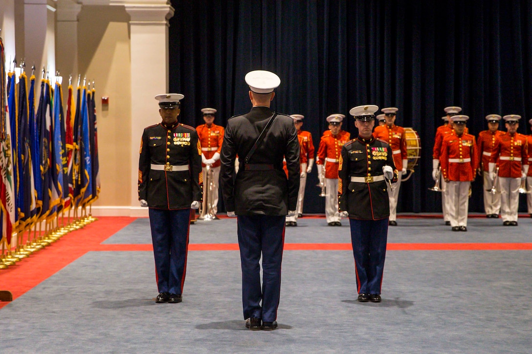 From left, Sgt. Maj. Jesse J. Dorsey, incoming sergeant major, Marine Barracks Washington, Col. Teague A. Pastel, commanding officer, MBW, and Sgt. Maj. Adrian L. Tagliere, outgoing sergeant major, MBW, stand at attention during a relief and appointment ceremony at MBW, Jan. 31, 2022.