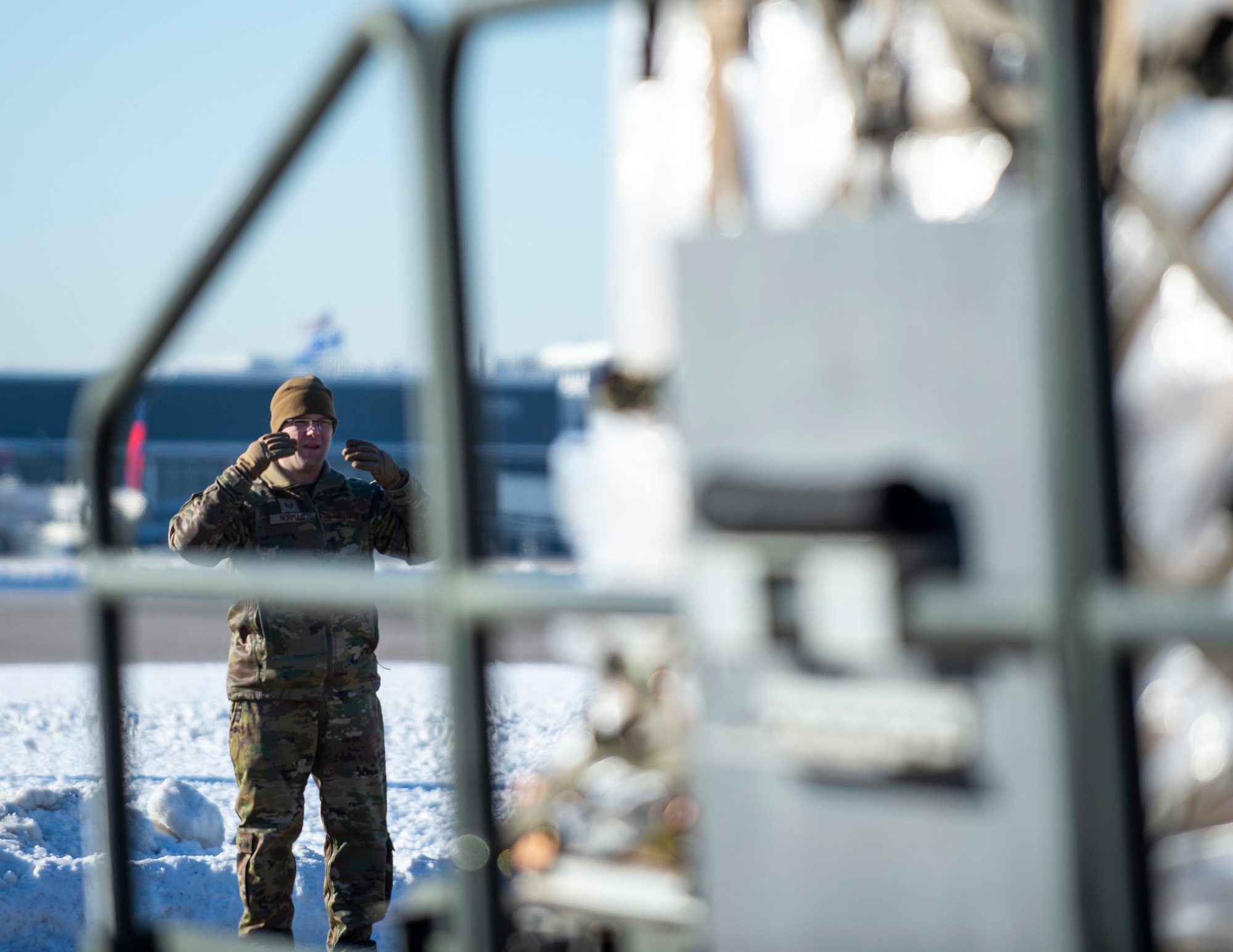 U.S. Air Force Tech. Sgt. Trevor Norman, 133rd Air Transportation Function, provides directions to a K-loader operator in St. Paul, Minn., Jan. 20, 2022.