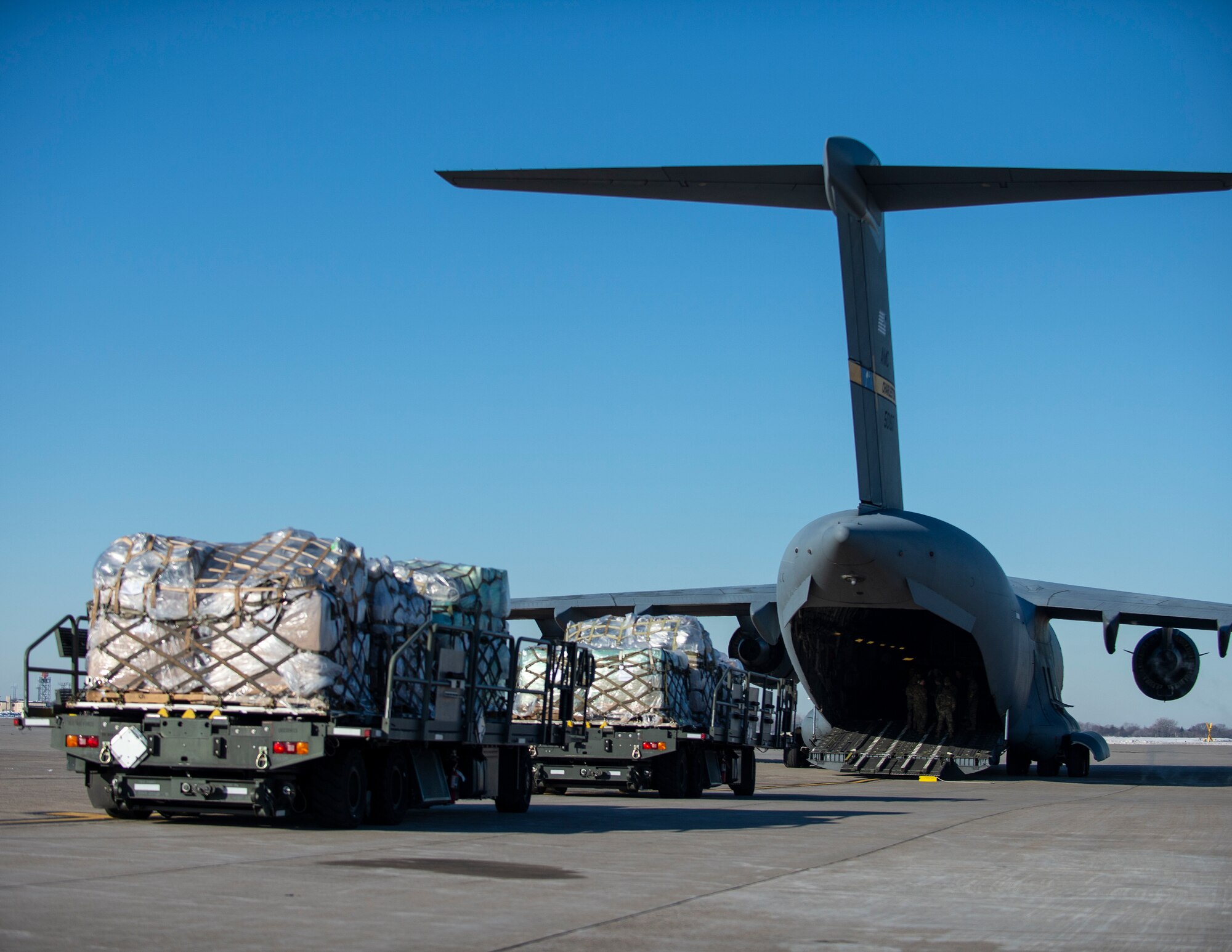 U.S. Air Force Airmen from the 133rd Air Transportation Function, prepare to load an estimated 11,300 pounds of medical supplies onto a C-17 Globemaster in St. Paul, Minn., Jan. 20, 2022.
