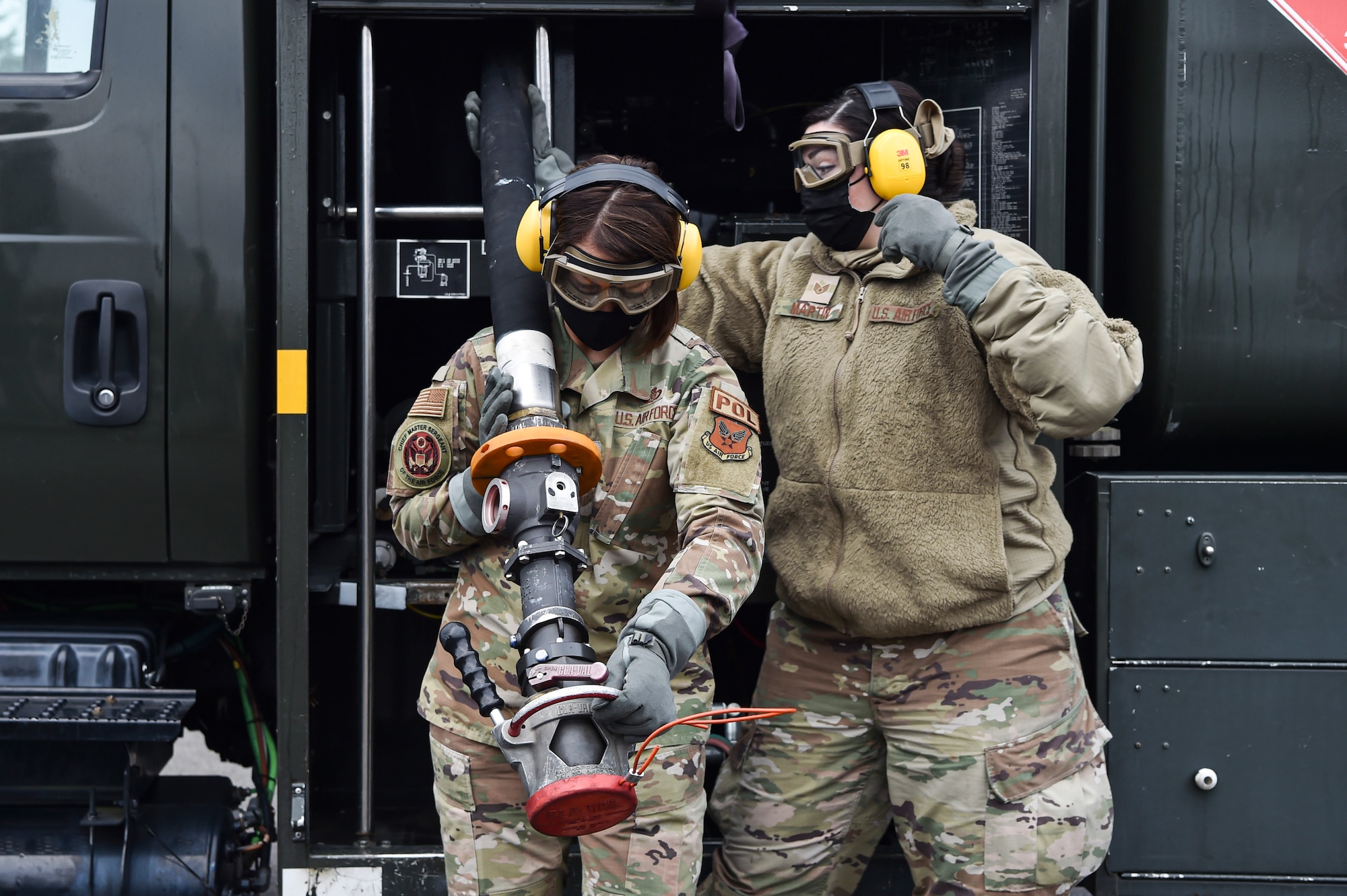 Chief Master Sergeant of the Air Force JoAnne S. Bass learns how to conduct specialized fueling operations with assistance from Staff Sgt. Kristin Martin, 627th Logistics Readiness Squadron fuels distribution supervisor, at Joint Base Lewis-McChord, Washington, Feb. 1, 2022. During her visit, Bass toured several McChord units and recognized Airmen for excellent performance. (U.S. Air Force photo by Staff Sgt. Tryphena Mayhugh)