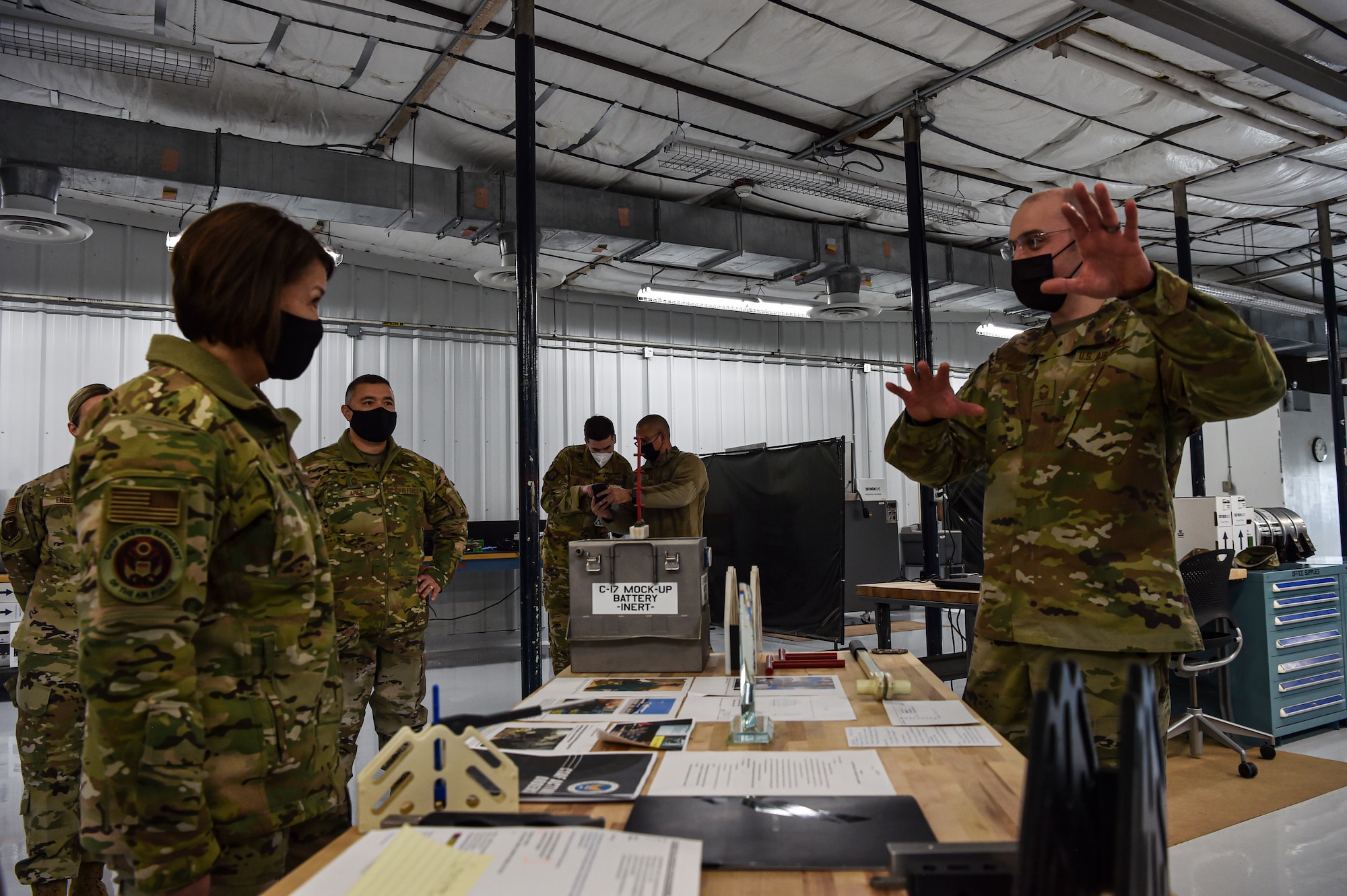 Chief Master Sergeant of the Air Force JoAnne S. Bass learns about a 3-D printed innovative battery cell extraction tool for a C-17 Globemaster III from Senior Master Sgt. Robert Tingle, 446th Maintenance Squadron accessories flight chief, during her visit to McChord Field at Joint Base Lewis-McChord, Washington, Feb. 1, 2022. During her visit, Bass toured several McChord units and recognized Airmen for excellent performance. (U.S. Air Force photo by Staff Sgt. Tryphena Mayhugh)