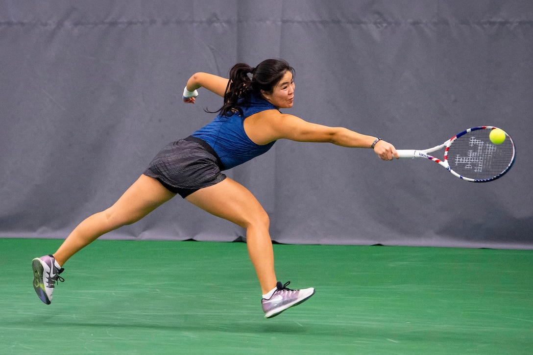 A tennis player hits a ball.