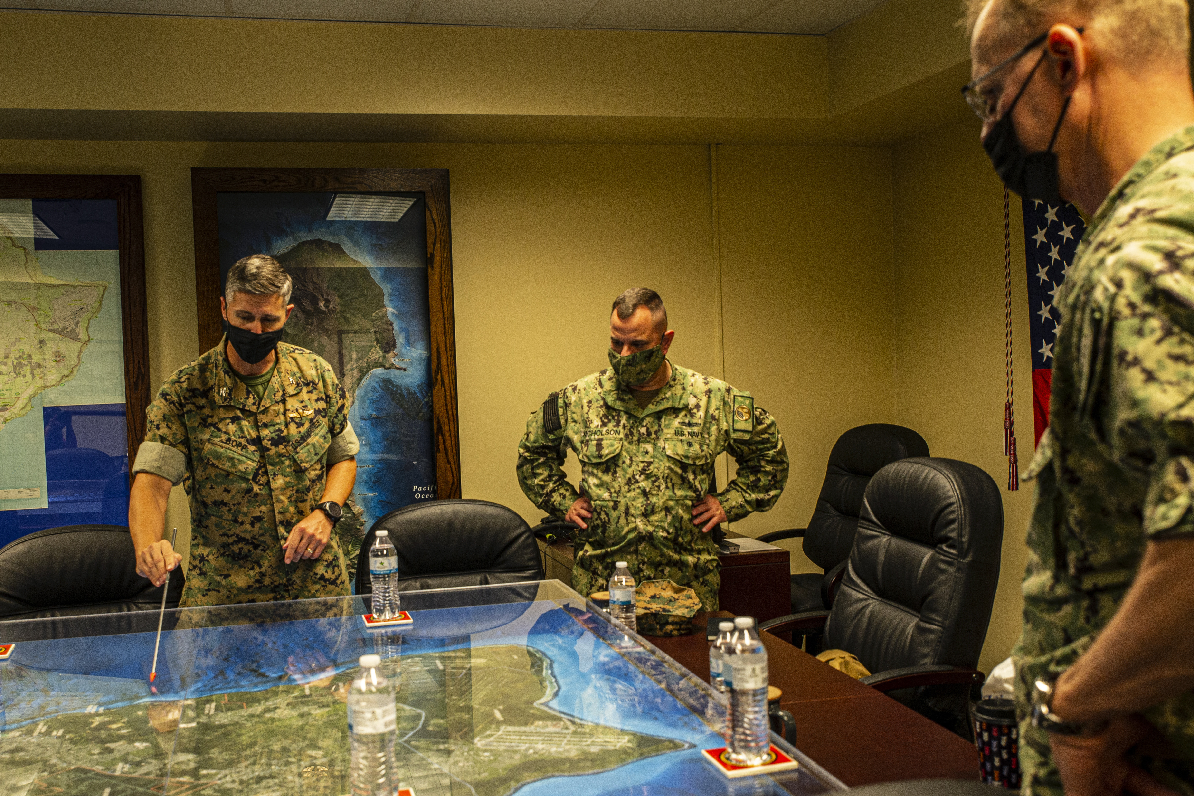 U.S. Marine Corps Col. Christopher Bopp, the commanding officer of Marine Corps Base (MCB) Camp Blaz, left, gives an orientation brief to U.S. Navy Rear Adm. Benjamin Nicholson, the commander of Joint Region Marianas, middle, and Vice Adm. Yancy B. Lindsey, the commander of Navy Installations Command, right, during a visit to MCB Camp Blaz, Guam, Feb. 1, 2022.