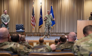 A man stands on a stage speaking to a crowd.