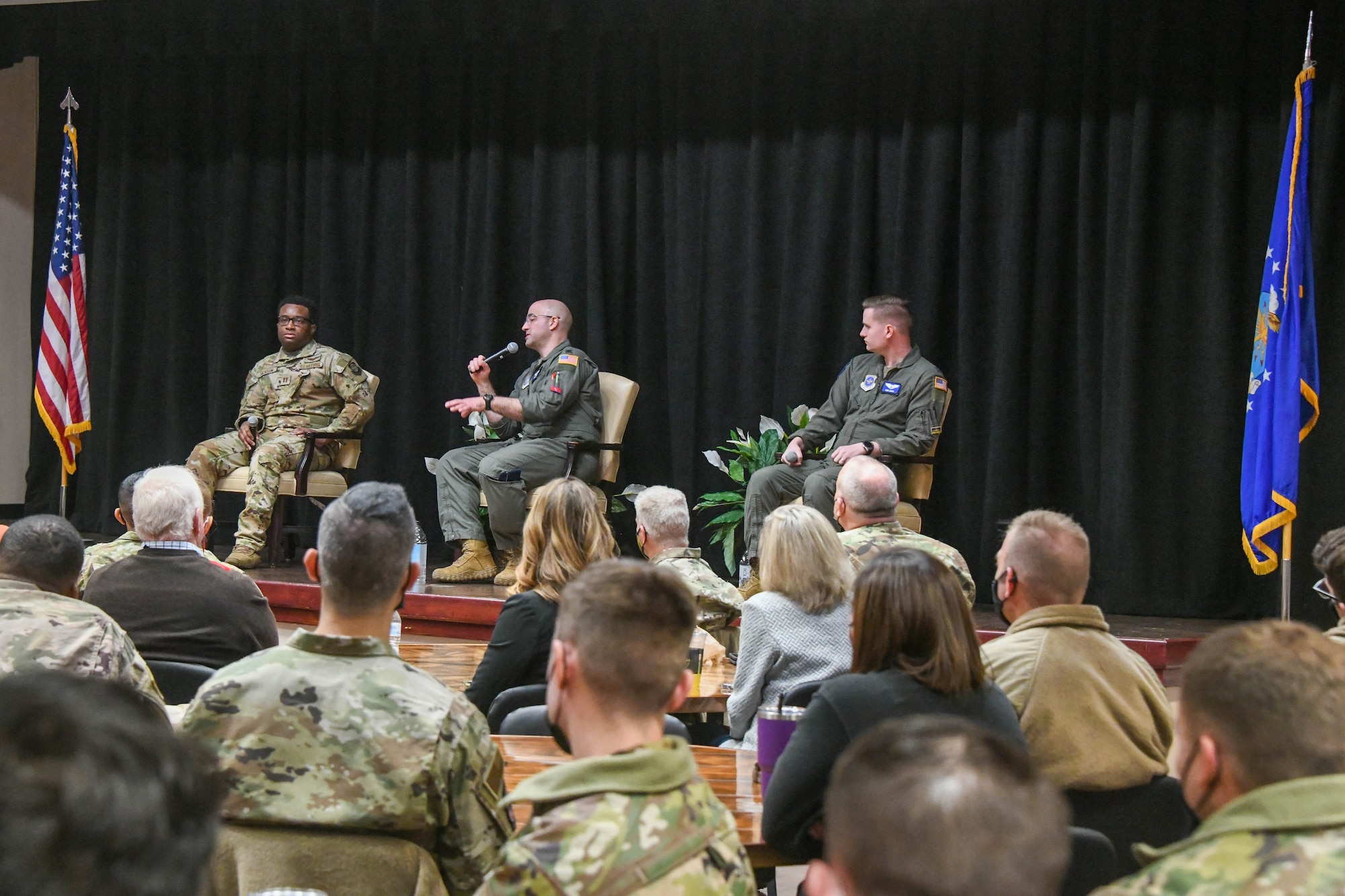 Airmen talk on stage while others listen