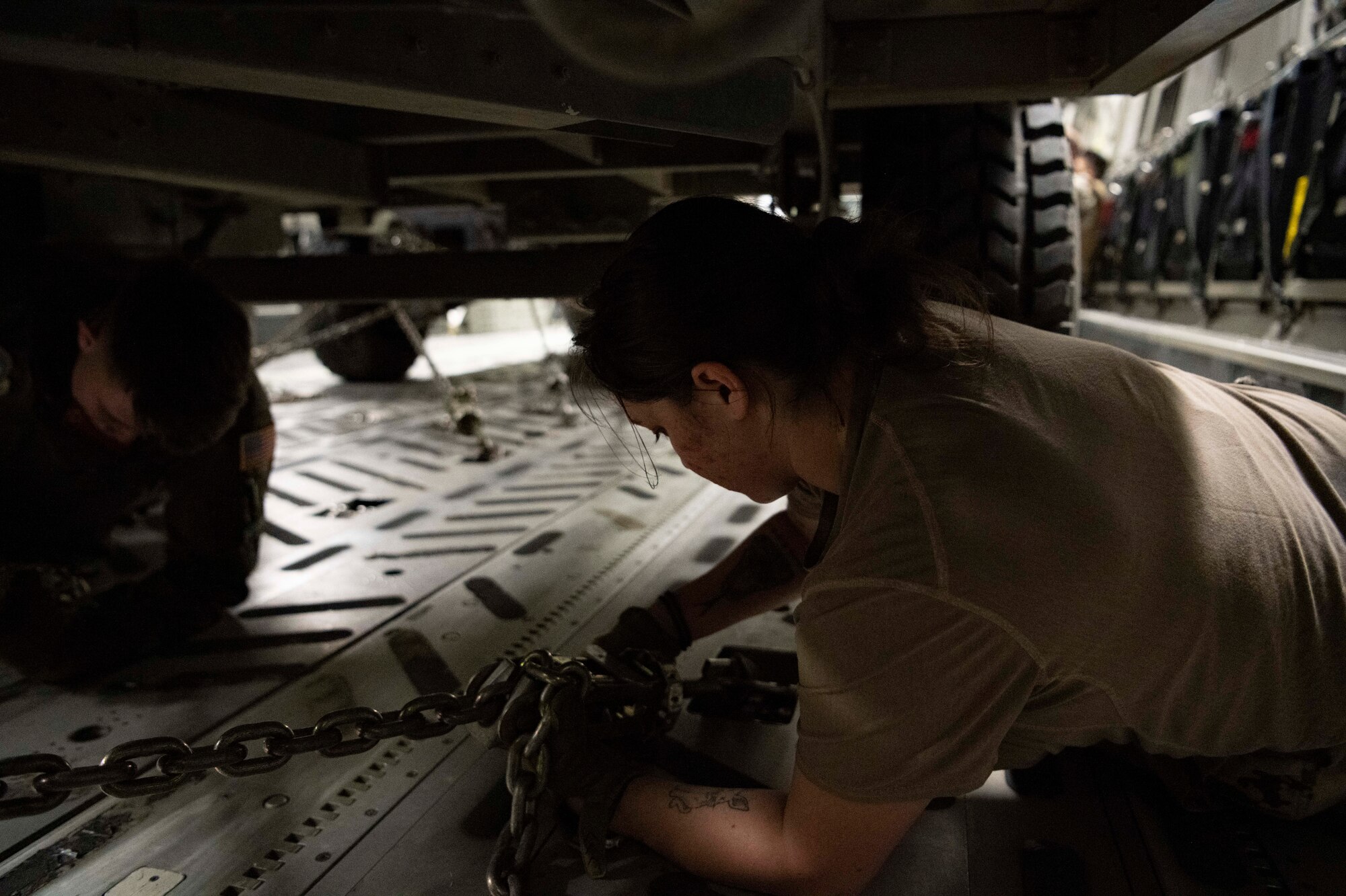 people chain vehicles to floor of an aircraft