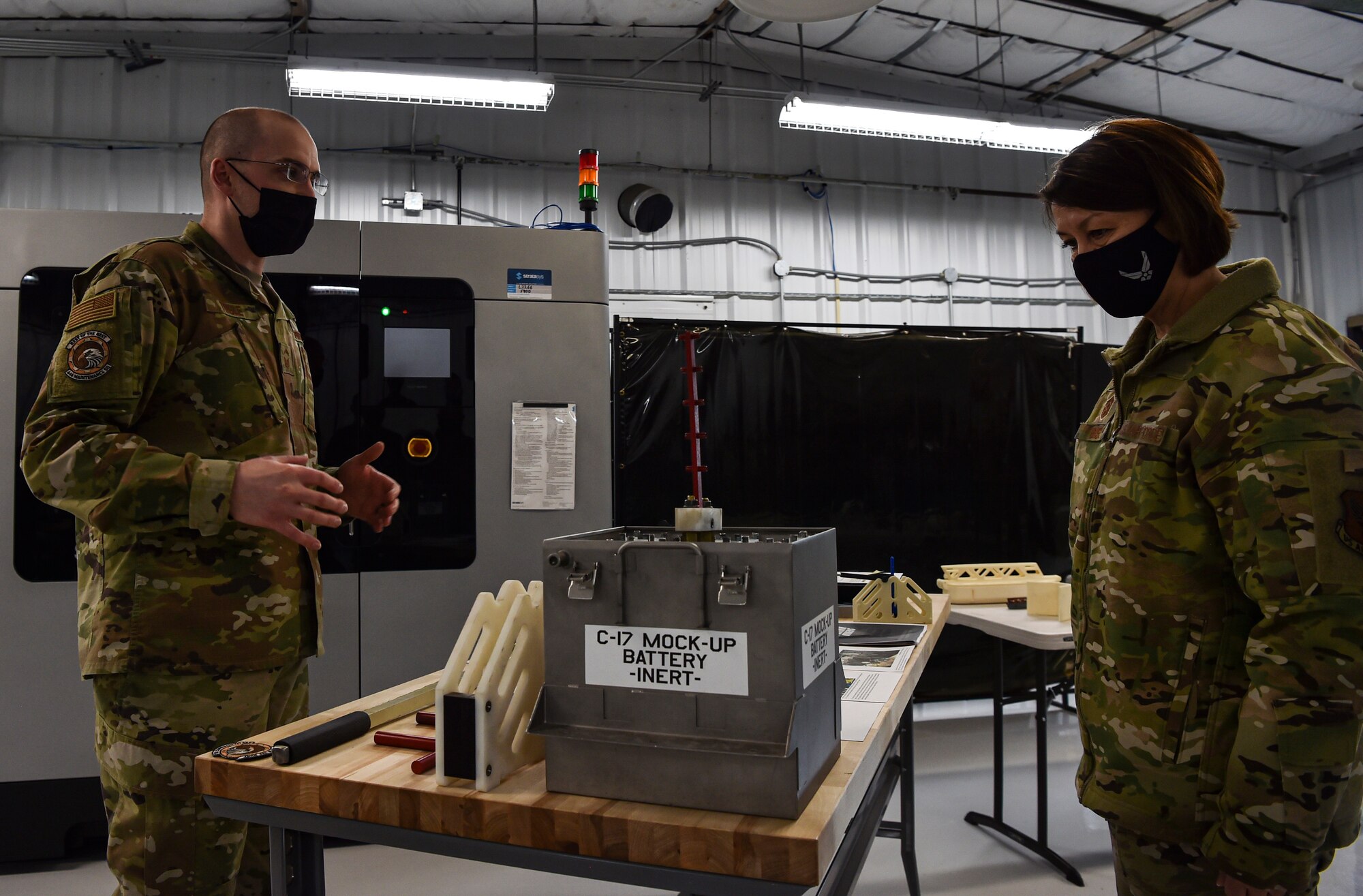 Chief Master Sergeant of the Air Force JoAnne S. Bass learns about a 3-D printed innovative battery cell extraction tool for a C-17 Globemaster III from Senior Master Sgt. Robert Tingle, 446th Maintenance Squadron accessories flight chief, during her visit to McChord Field at Joint Base Lewis-McChord, Washington, Feb. 1, 2022. During her visit, Bass toured several McChord units and recognized Airmen for excellent performance. (U.S. Air Force photo by Staff Sgt. Tryphena Mayhugh)