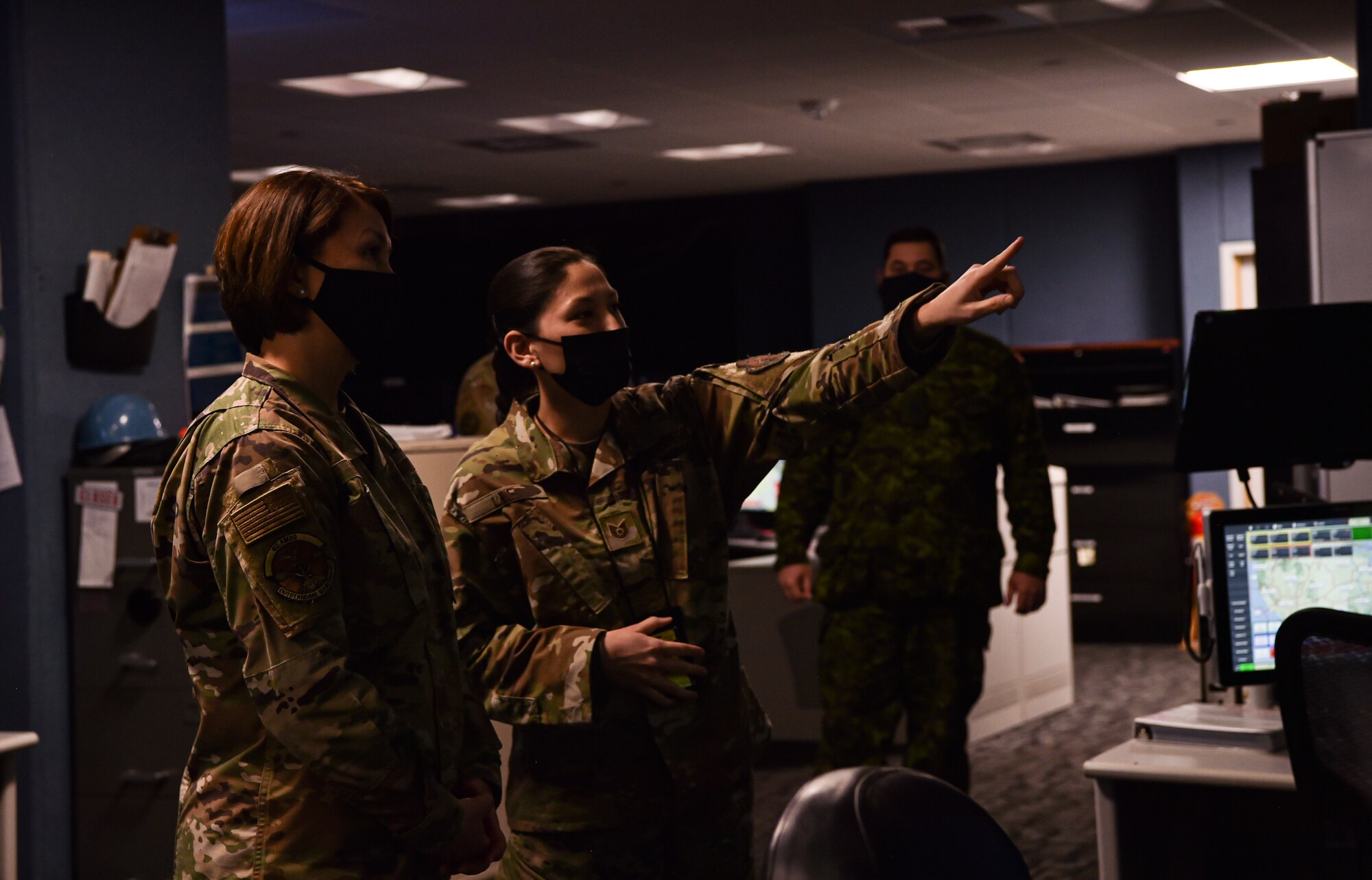 Chief Master Sergeant of the Air Force JoAnne S. Bass learns about the Western Air Defense Sector mission from Tech. Sgt. Michelle Lye, 225th Air Defense Squadron weapons director, from Tech. Sgt. Spencer Torres, 22nd Special Tactics Squadron radar airfield weather systems, during her visit to McChord Field at Joint Base Lewis-McChord, Washington, Feb. 1, 2022. Bass toured several McChord units and recognized Airmen for excellent performance. (U.S. Air Force photo by Staff Sgt. Tryphena Mayhugh)