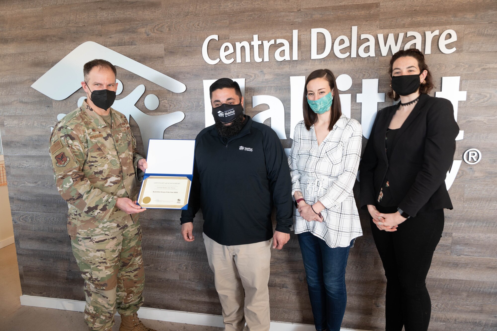 Col. Matt Husemann, 436th Airlift Wing commander, accepts 2021 Build Site Volunteer organization of the year award presented by Timothy Bailey, central Delaware Habitat for Humanity executive director at Dover, Delaware, Feb. 1, 2022. The award is presented annually to the volunteer group who makes the most impact in the local community. Airmen from Dover Air Force Base volunteered throughout the year helping with several home construction projects. (U.S. Air Force photo by Mauricio Campino)