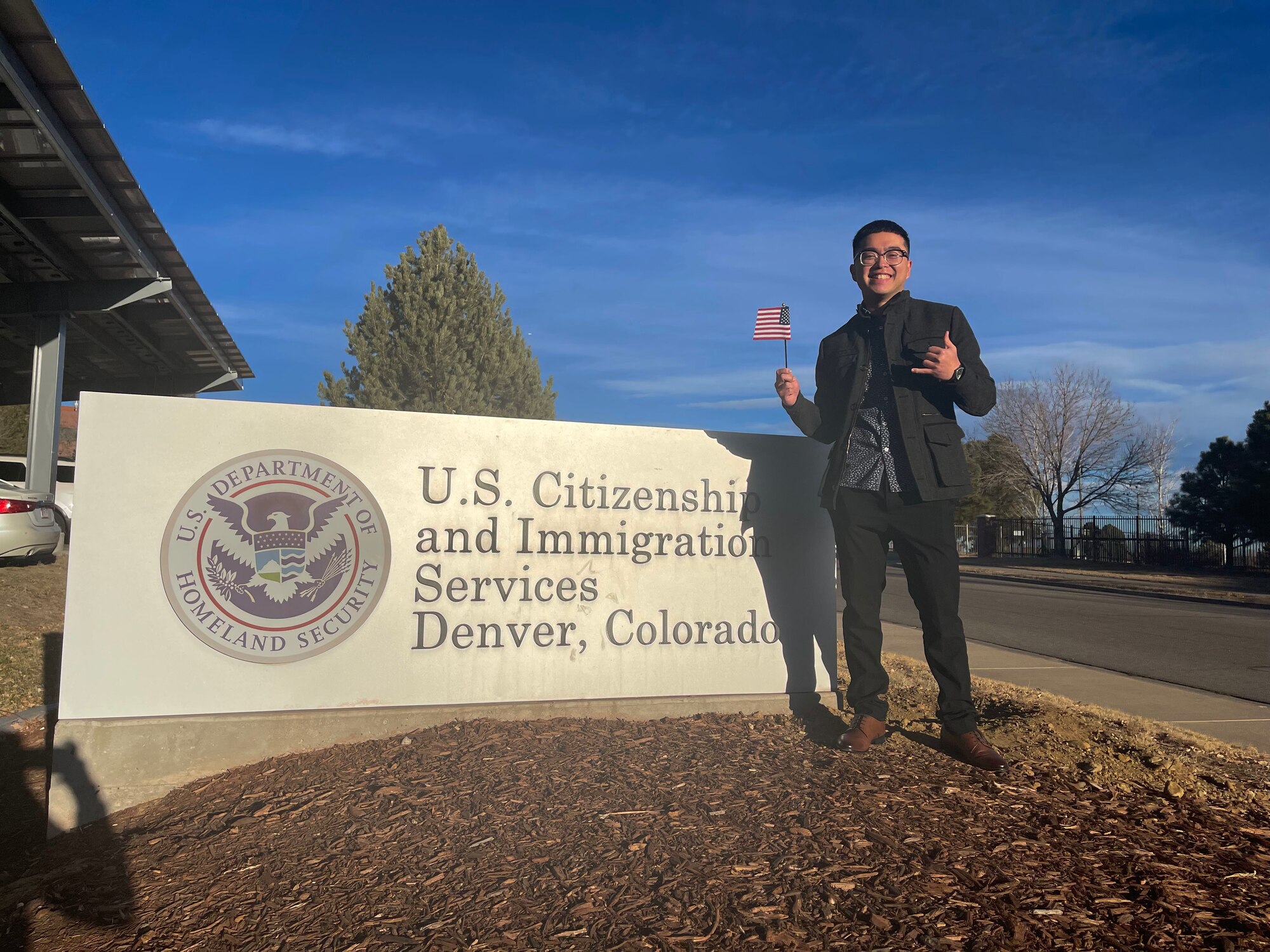 person stands in front of building sign