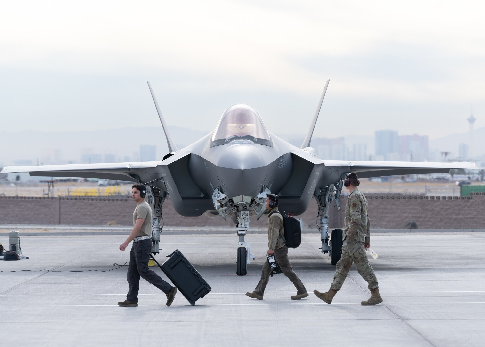 A photo of F-35 maintainers walking past a jet