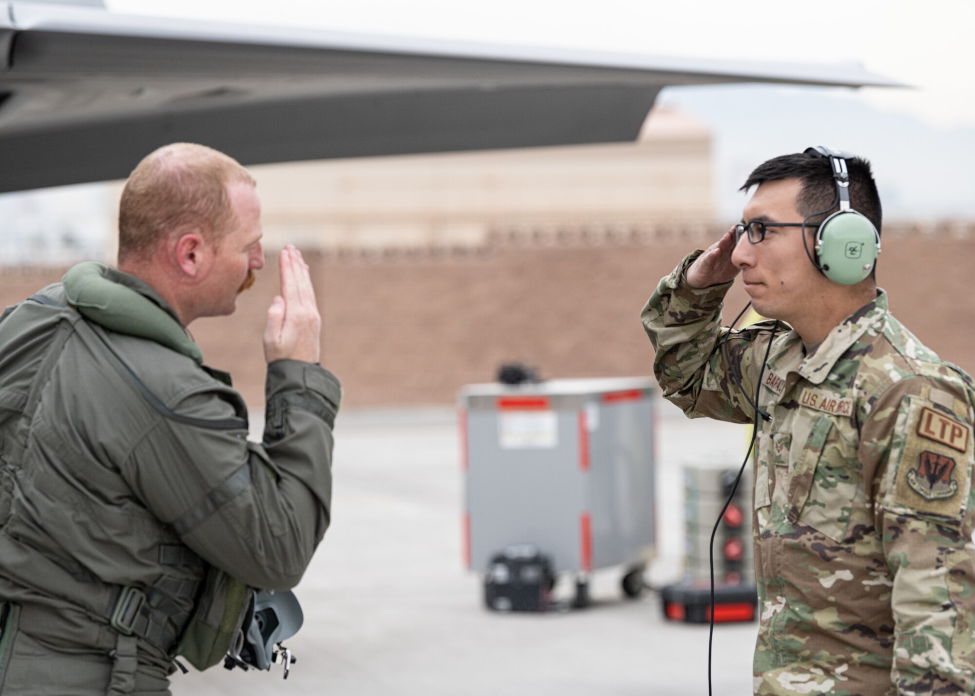 A photo of a maintainer and pilot saluting