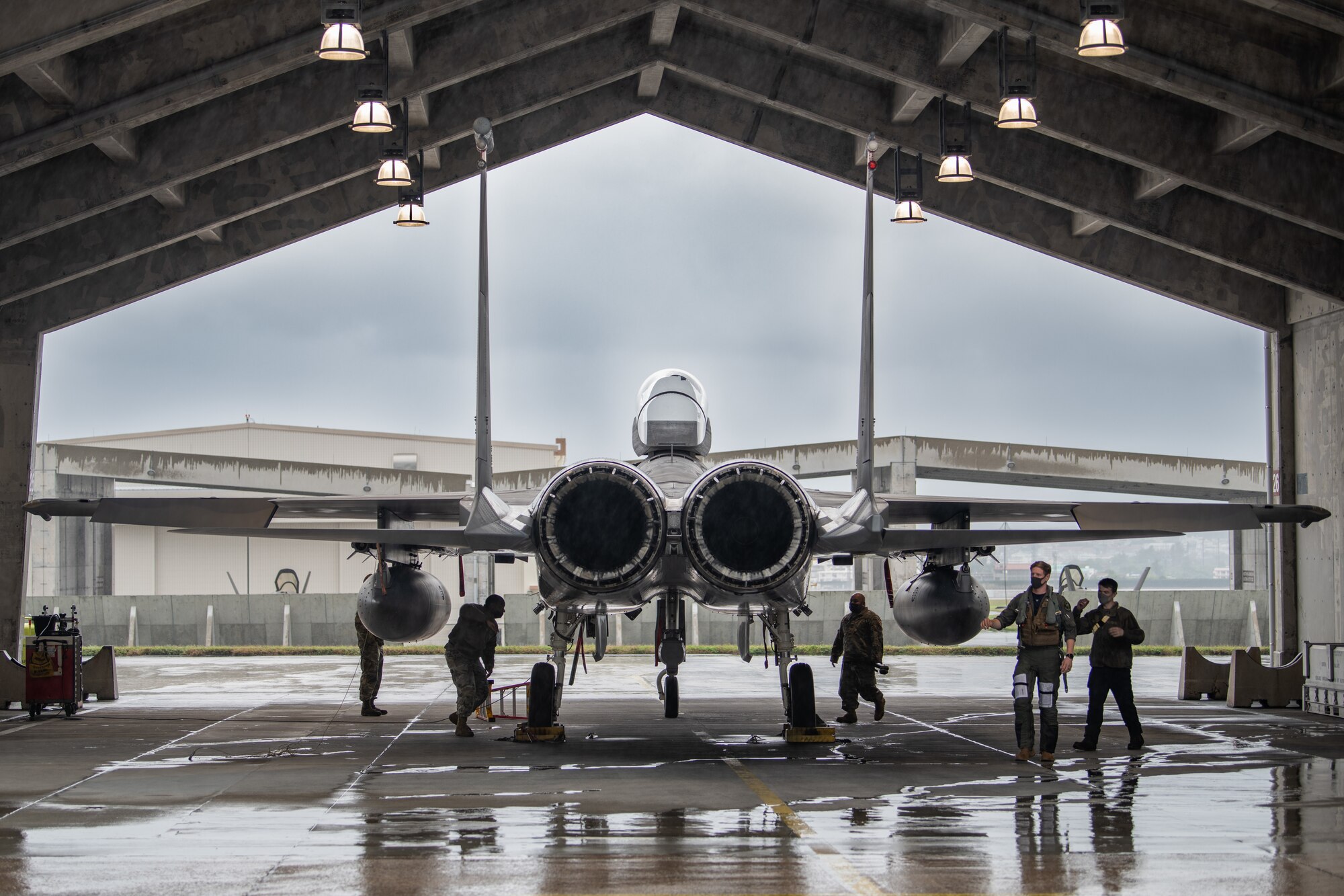 A fighter jet sits under an outdoor canopy