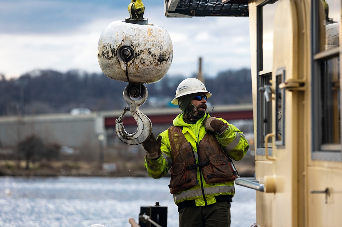 Chuck Hire, a Marine Technologies, Inc. pilings supervisor, radios for assistance during construction modifications of the U.S. Army Corps of Engineers, Baltimore District’s, DC Drift field office dock’s alongside the Anacostia River, Jan 18, 2022. The upgrades will allow ample parking space to accommodate the newly arriving NACOTCHTANK Floating Crane. The NACOTCHTANK, affectionately named after the semi-agrarian band of Algonquian tribe members who lived at the Potomac and Anacostia Rivers confluence for over 1,000 years, is an 85-foot crane barge equipped with a 15-ton crane. (U.S. Army photo by Greg Nash)