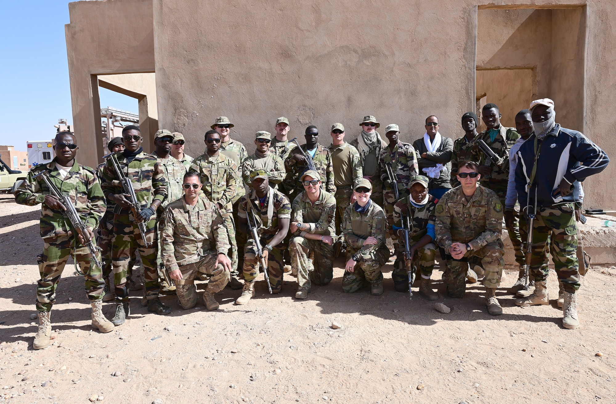 The 409th Expeditionary Security Forces Squadron air advisors, 724th Expeditionary Air Base Squadron firefighters and Nigerien Armed Forces (French language: Forces Armées Nigeriennes), take a group photo after training at Nigerien Air Base 201, Agadez, Niger, Jan. 21, 2022 This training is part of an eight-week course, in which 30 FAN members trained on a variety of tactics to help strengthen their defense capabilities and counter-transnational threats. (U.S. Air Force photo by Tech. Sergeant Stephanie Longoria)