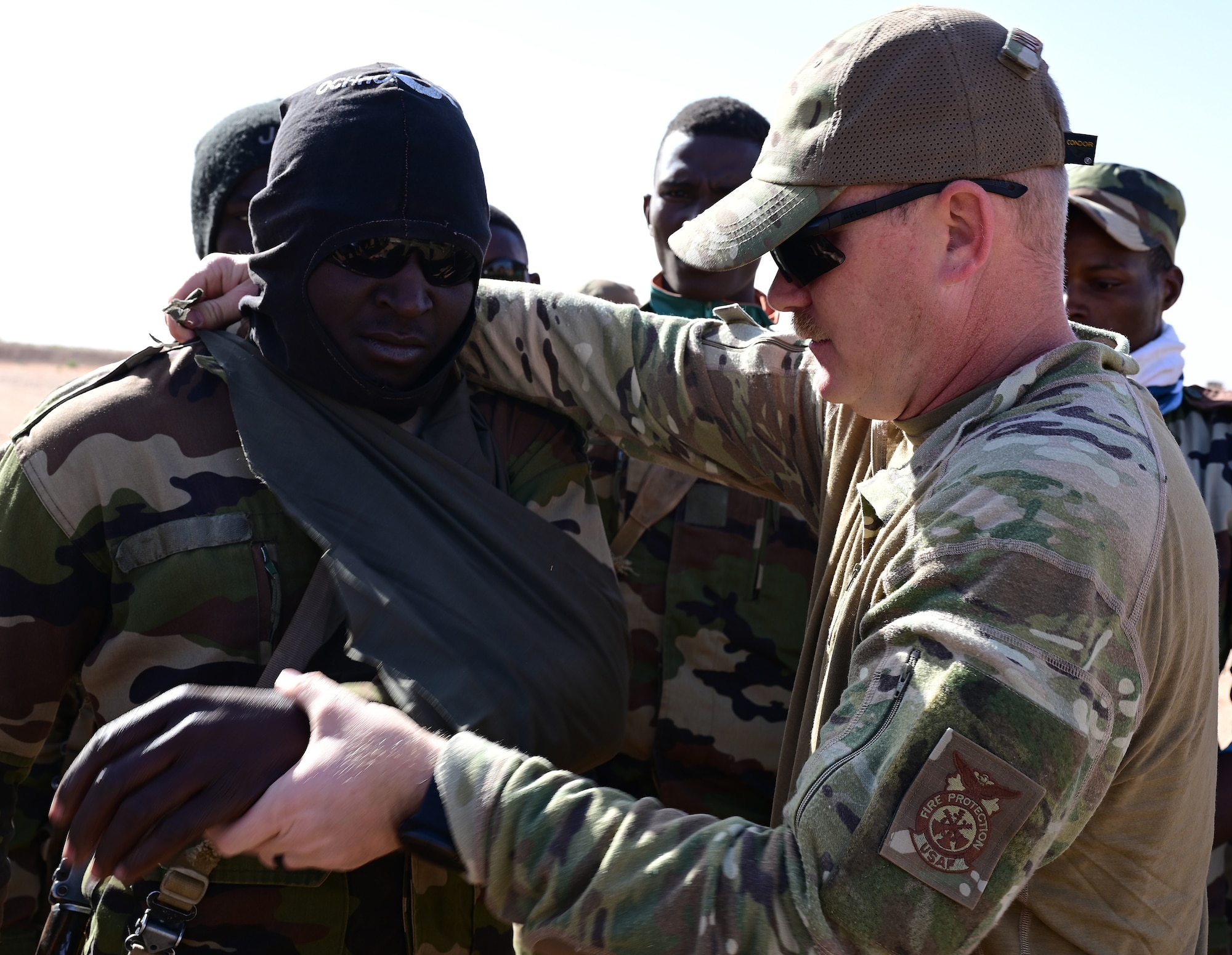 U.S. Air Force Tech. Sgt. Sean Douglas, 724th Expeditionary Air Base Squadron firefighter, demonstrates how to sling an arm injury during a training with Nigerien Armed Forces (French language: Forces Armées Nigeriennes) at Nigerien Air Base 201, Agadez, Niger, Jan. 21, 2022. Thirty FAN members attended an eight-week military operations course to enhance their ability to disrupt, degrade and neutralize violent extremist organizations in the area.  (U.S. Air Force photo by Tech. Sgt. Stephanie Longoria)