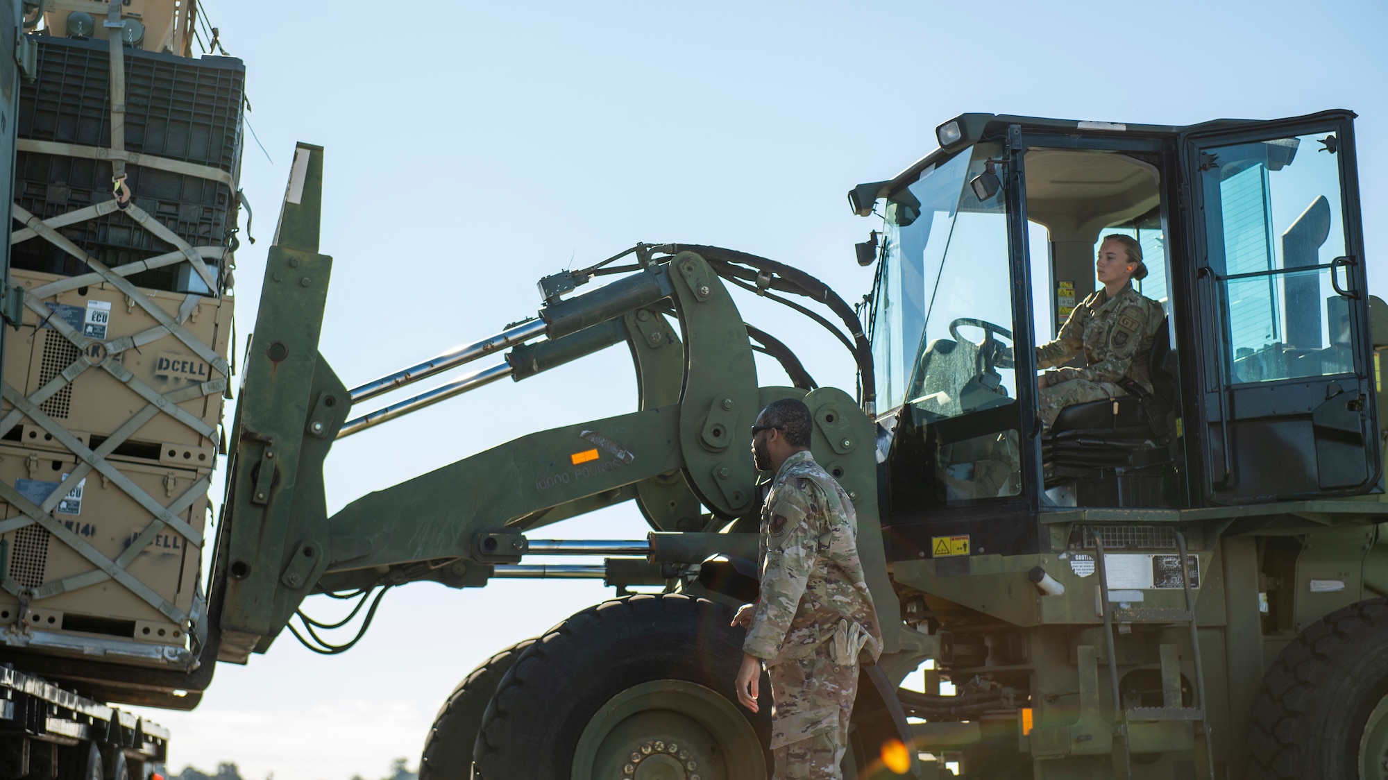 U.S. Air Force Tech. Sgt. Ismael Hayes, the noncommissioned officer in charge of Air Transportation for the 24th Special Operations Wing (SOW), Detachment 1, and Airman 1st Class Zoe Stough, a ground transportation support operator with the 6th Logistics Readiness Squadron, load cargo onto a semi-truck at MacDill Air Force Base, Florida, Feb. 1, 2022.