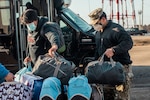 A sailor with Task Force Pickett, assists an Afghan evacuee during their final departure at Fort Pickett, Virginia on Feb. 1, 2022. The Department of Defense, through U.S. Northern Command, and in support of the Department of Homeland Security, is providing transportation, temporary housing, medical screening, and general support for at least 50,000 Afghan evacuees at suitable facilities, in permanent or temporary structures, as quickly as possible. This initiative provides Afghan personnel essential support at secure locations outside Afghanistan. (U.S. Marine Corps photo by Lance Cpl. David Intriago)