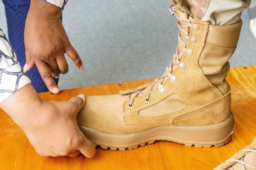 A person presses down on the toe of a boot.