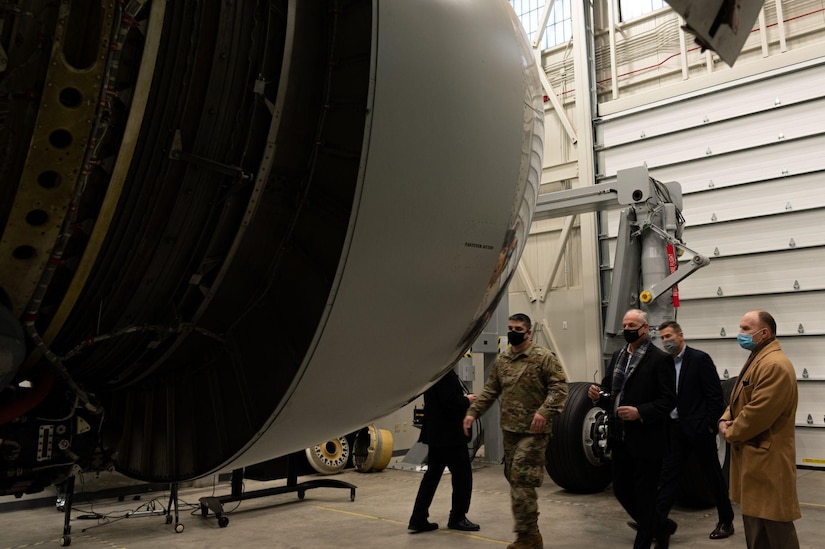 A group of people observe a KC-46 engine trainer