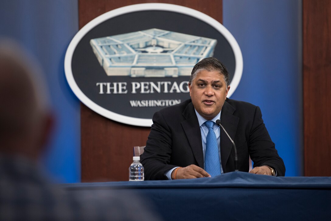 A man sits behind a microphone.