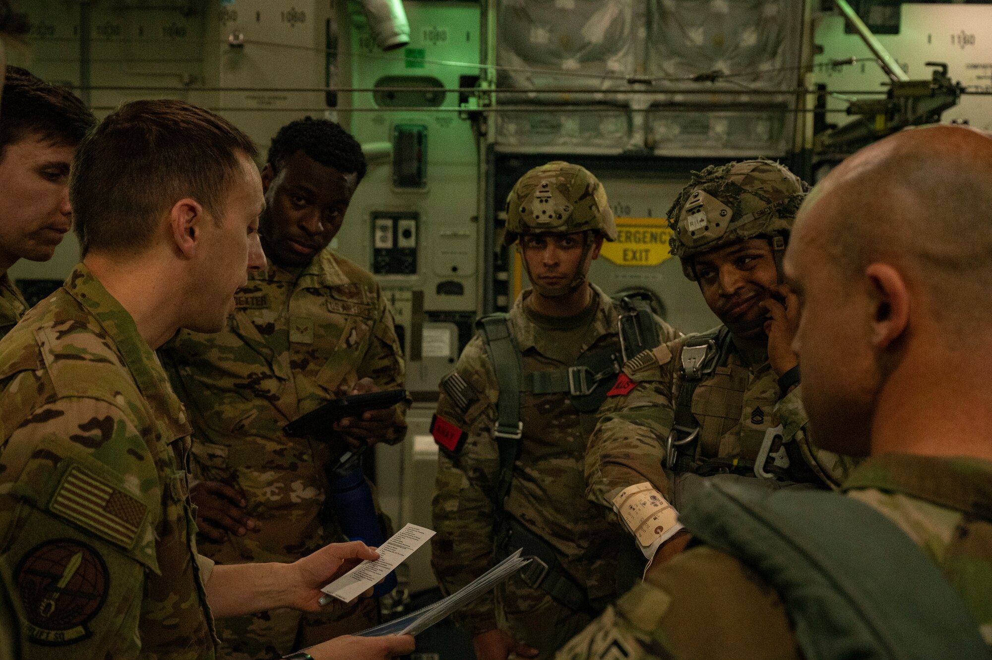 U.S. Air Force Maj. Matthew Weinberg, left, 7th Airlift Squadron pilot, briefs U.S. Army jumpmasters assigned to the 82nd Airborne Division, Fort Bragg, North Carolina, during Battalion Mass Tactical Week at Pope Army Airfield, North Carolina, Feb. 1, 2022. BMTW is a joint exercise between the U.S. Air Force and the U.S. Army, which gives participants the ability to practice contingency operations in a controlled environment. (U.S. Air Force photo by Airman 1st Class Charles Casner)