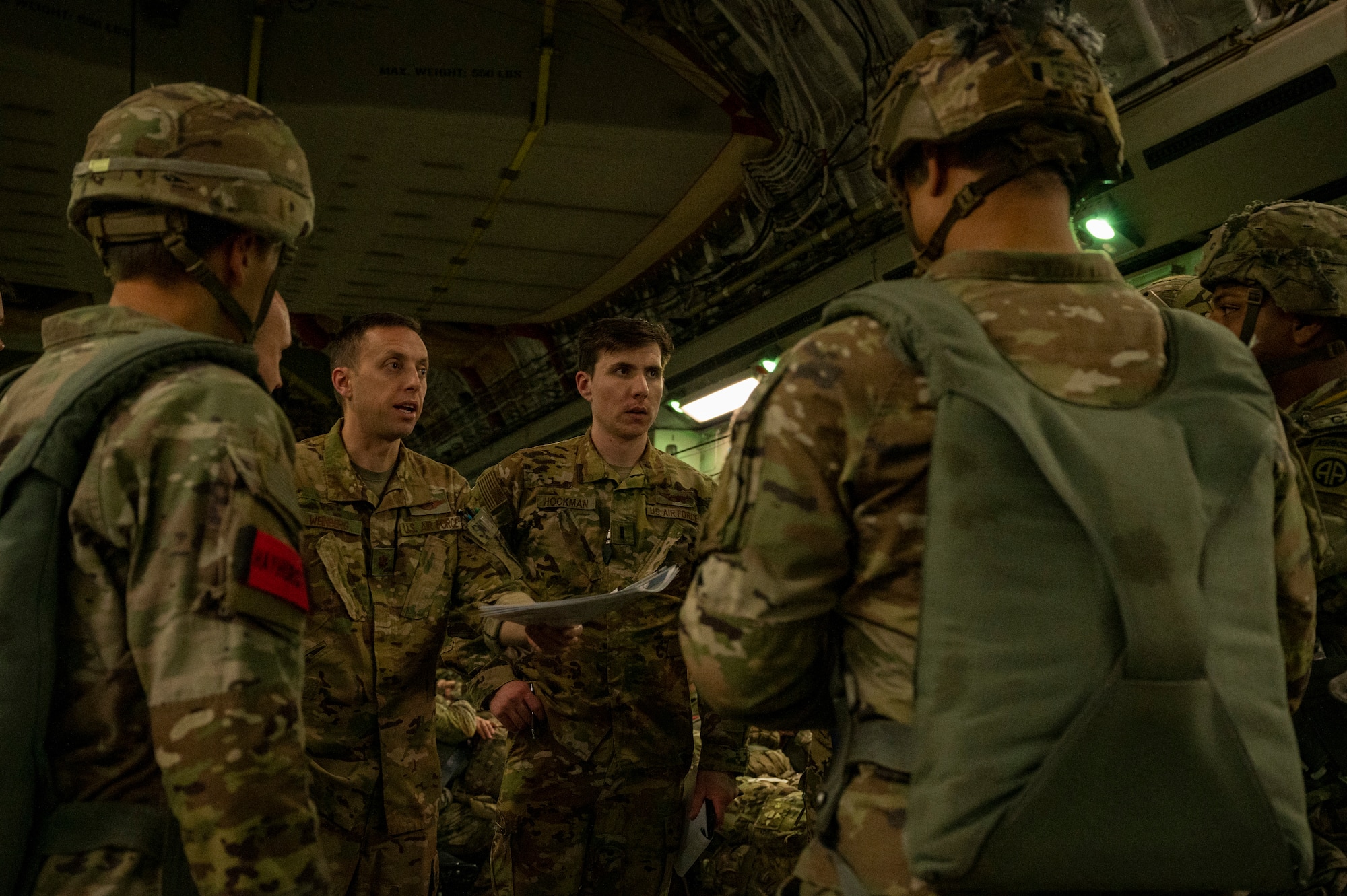 U.S. Air Force Maj. Matthew Weinberg, left, 7th Airlift Squadron pilot, briefs U.S. Army jumpmasters assigned to the 82nd Airborne Division, Fort Bragg, North Carolina, during Battalion Mass Tactical Week at Pope Army Airfield, North Carolina, Feb. 1, 2022. BMTW is a joint exercise between the U.S. Air Force and the U.S. Army, which gives participants the ability to practice contingency operations in a controlled environment. (U.S. Air Force photo by Airman 1st Class Charles Casner)