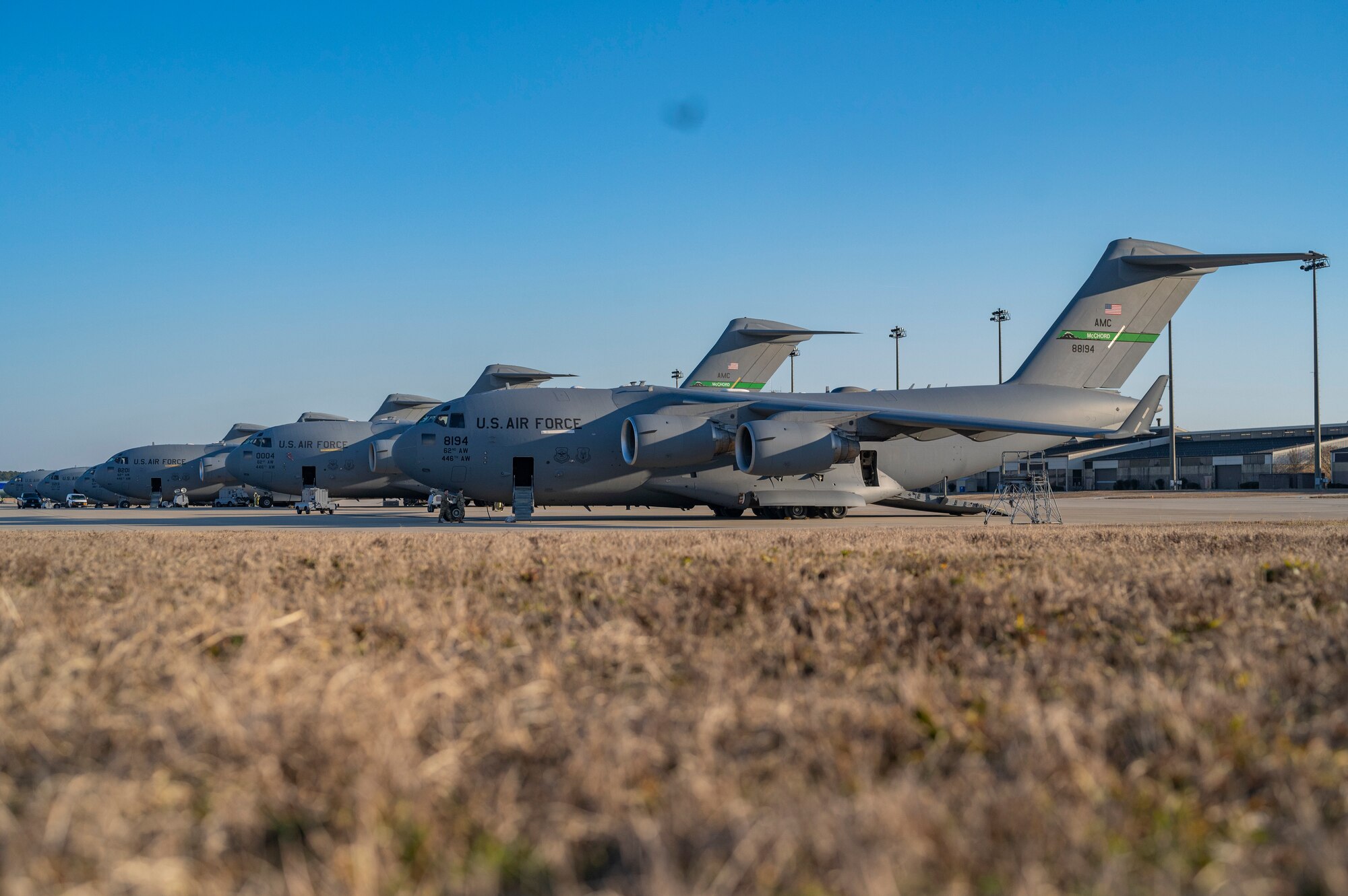 A Fleet of C-17 Globemaster IIIs assigned to Joint Base Lewis-McChord, Washington, and Joint Base Charleston, South Carolina, prepare to takeoff during Battalion Mass Tactical Week, or BMTW, at Pope Army Airfield, North Carolina, Feb. 1, 2022. BMTW is a joint exercise between the U.S. Air Force and the U.S. Army, which gives participants the ability to practice contingency operations in a controlled environment. (U.S. Air Force photo by Airman 1st Class Charles Casner)
