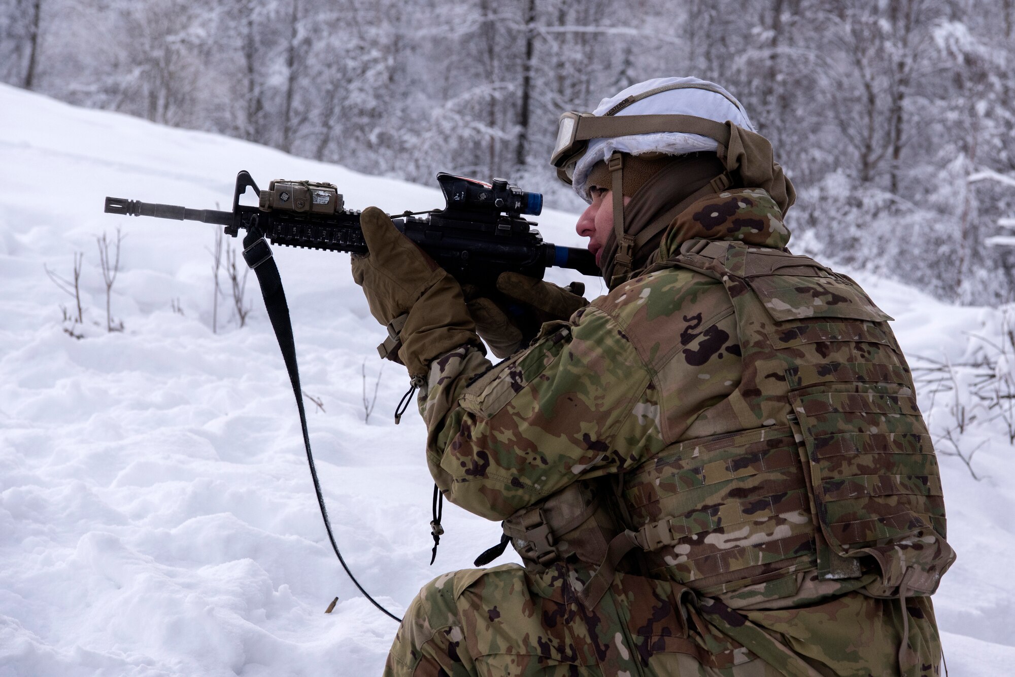 A U.S. Army paratrooper assigned to A Troop, 1st Squadron (Airborne), 40th Cavalry Regiment, 4th Infantry Brigade Combat Team (Airborne), 25th Infantry Division, U.S. Army Alaska, engages a simulated enemy position on the Light Infantry Collective Training Course at Joint Base Elmendorf-Richardson, Alaska, Feb. 2, 2022. Cavalry scouts conducted live-fire maneuver training which focused on eliminating simulated enemy positions through fire team movement. USARAK trains year-round to increase lethal combat support in an arctic environment.