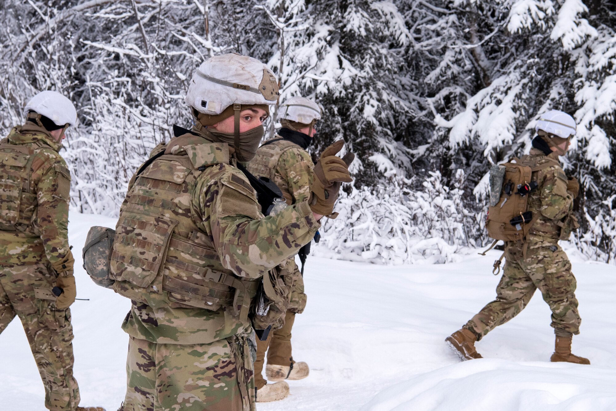 A U.S. Army paratrooper assigned to A Troop, 1st Squadron (Airborne), 40th Cavalry Regiment, 4th Infantry Brigade Combat Team (Airborne), 25th Infantry Division, U.S. Army Alaska, relays instructions to his patrol on the Light Infantry Collective Training Course at Joint Base Elmendorf-Richardson, Alaska, Feb. 2, 2022. Cavalry scouts conducted live-fire maneuver training which focused on eliminating simulated enemy positions through fire team movement. USARAK trains year-round to increase lethal combat support in an arctic environment.