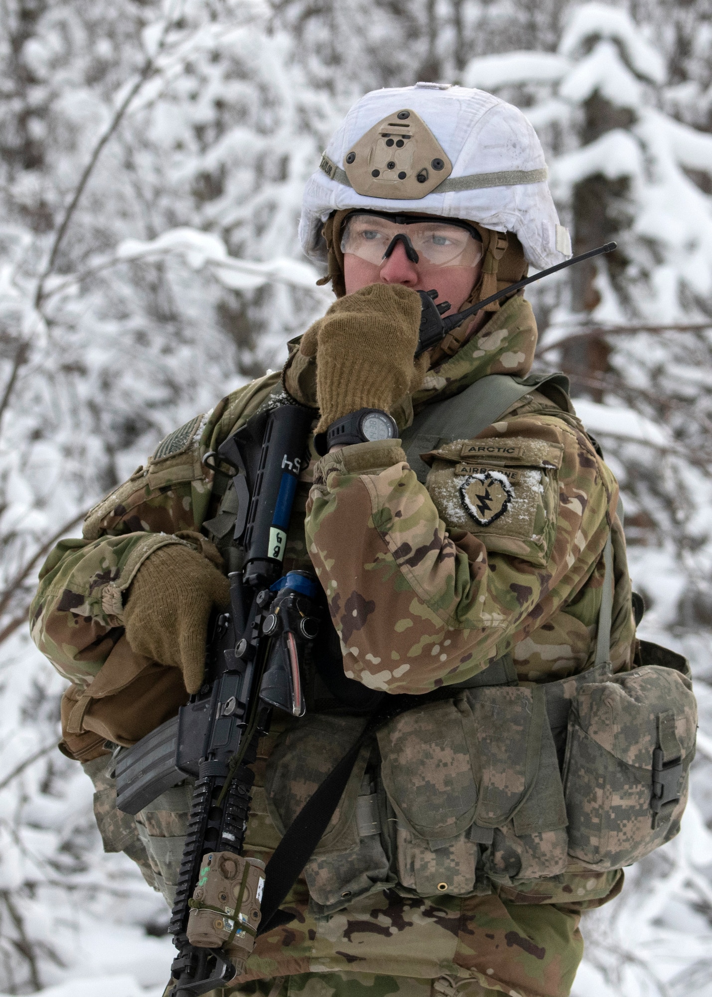 A U.S. Army Sgt. Brandon Taylor, a fire team leader assigned to A Troop, 1st Squadron (Airborne), 40th Cavalry Regiment, 4th Infantry Brigade Combat Team (Airborne), 25th Infantry Division, U.S. Army Alaska, communicates with another fire team on the Light Infantry Collective Training Course at Joint Base Elmendorf-Richardson, Alaska, Feb. 2, 2022. Cavalry scouts conducted live-fire maneuver training which focused on eliminating simulated enemy positions through fire team movement. USARAK trains year-round to increase lethal combat support in an arctic environment.