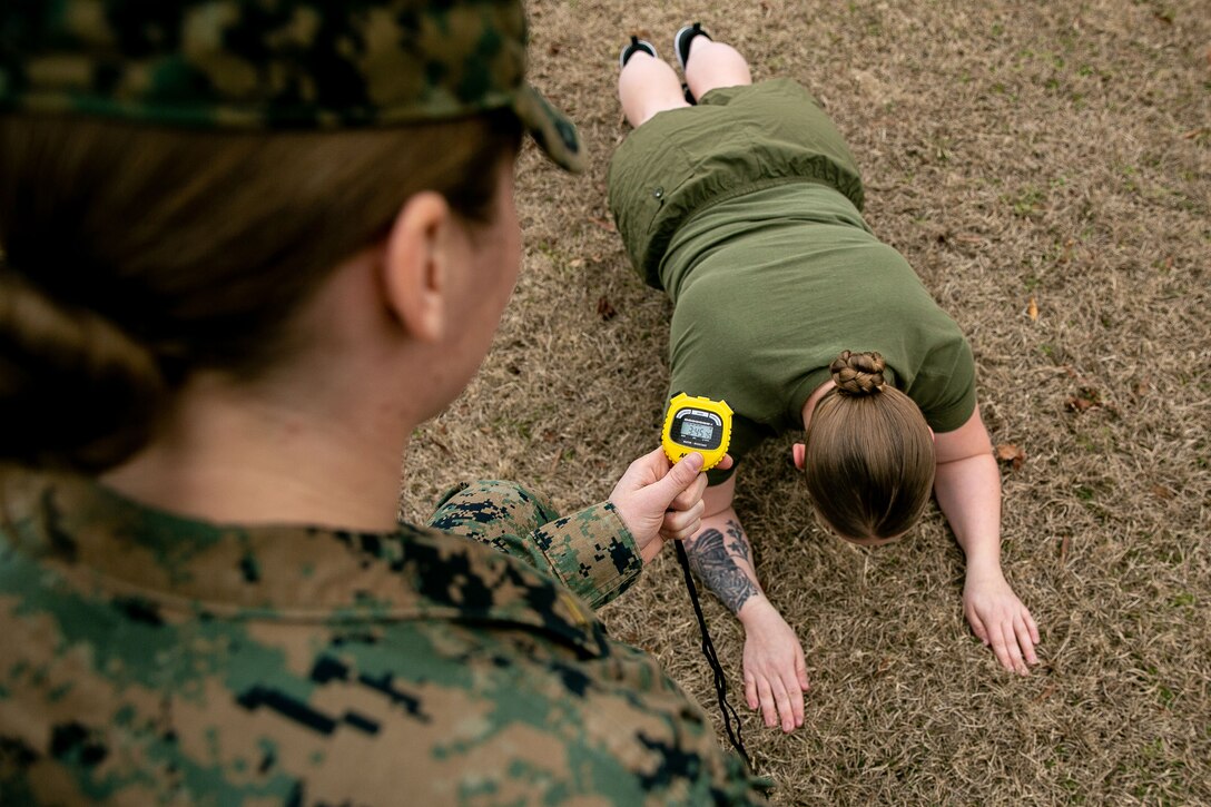 A Marine does planks while another monitors.