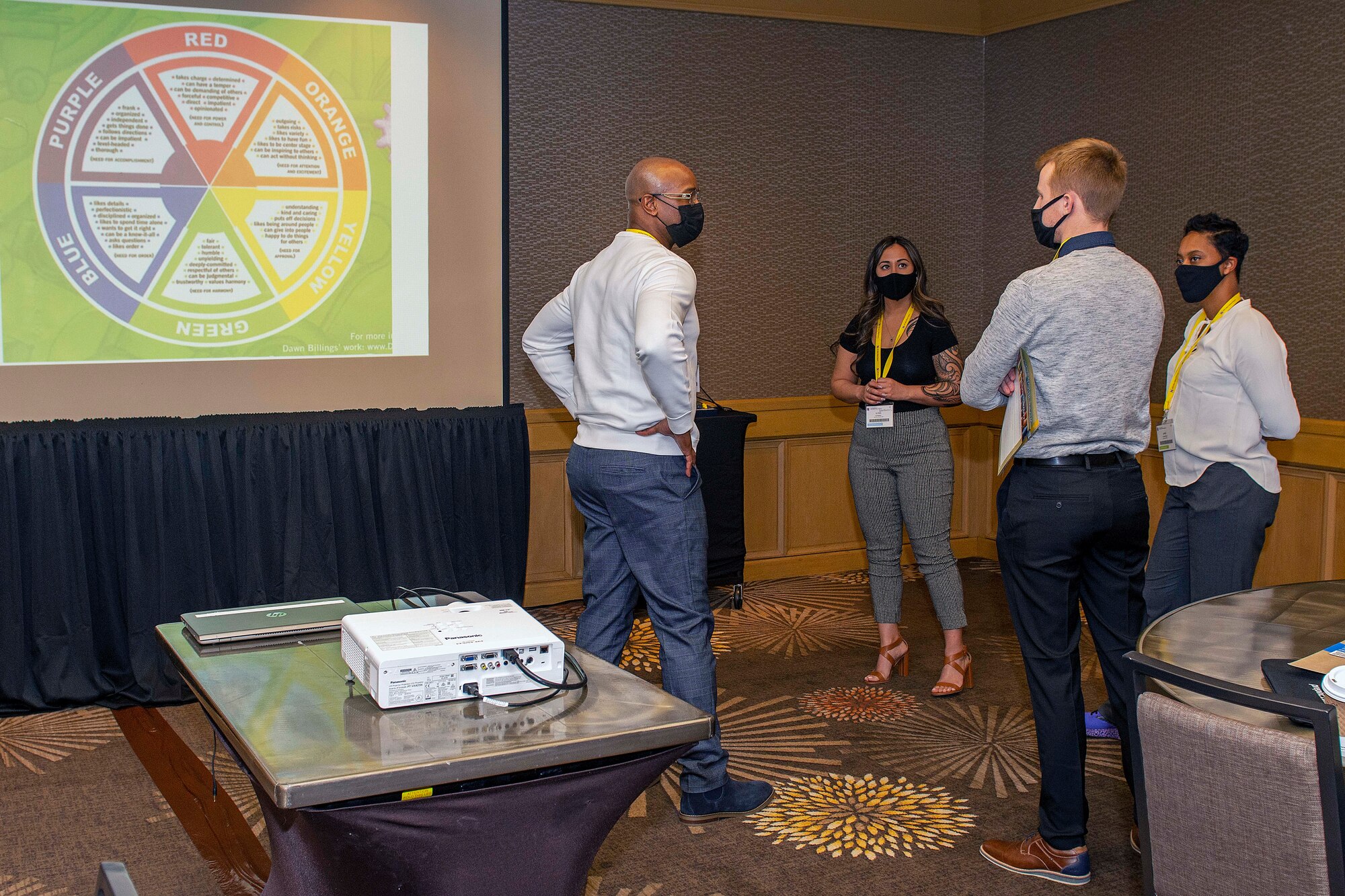 Photo of four individuals standing around talking.