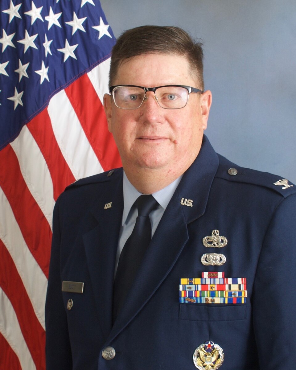 Official studio photo of a colonel in front of American flag
