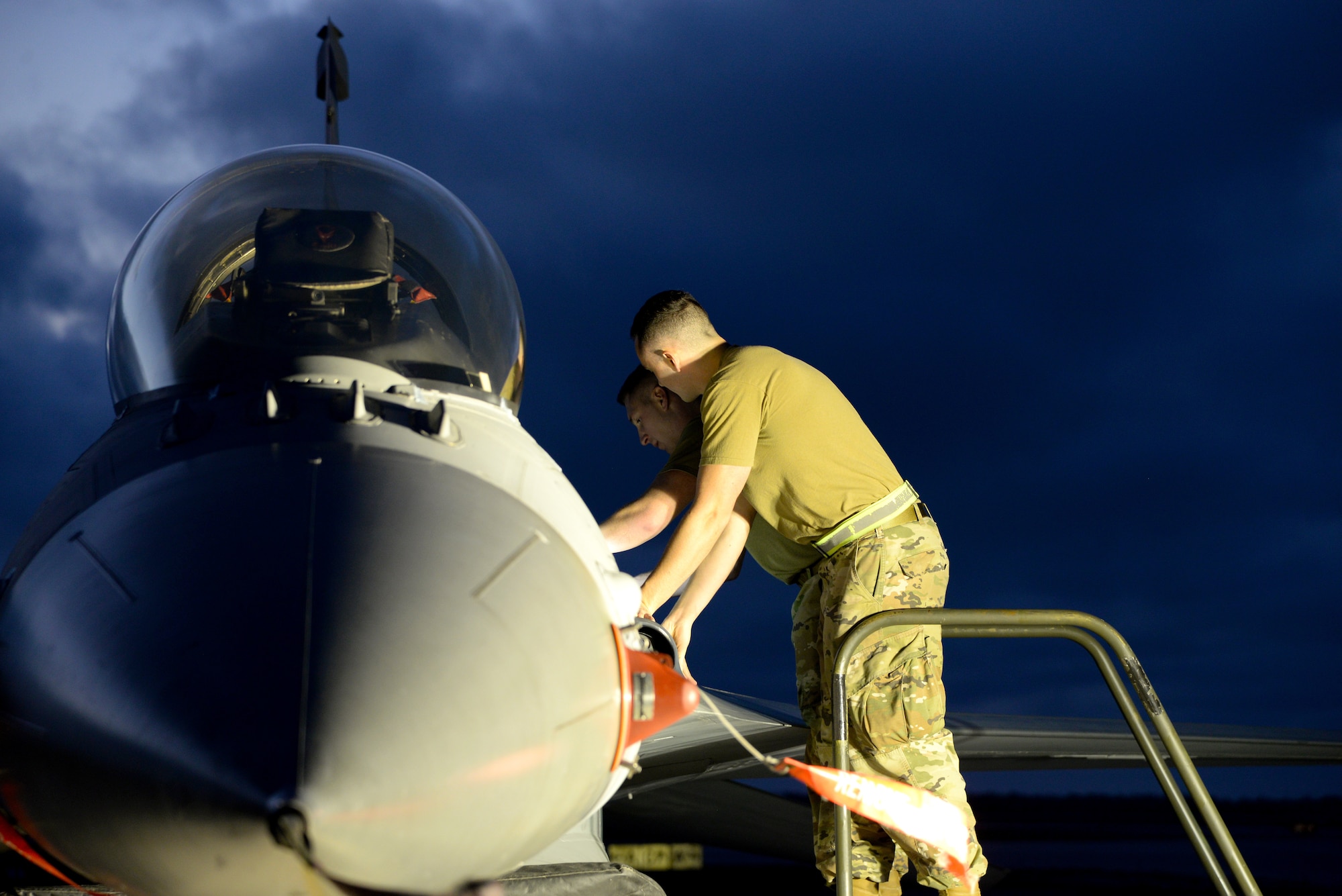 An image of electrical bioenvironmental technicians with the 177th Fighter Wing of the New Jersey Air National Guard, changing a bioenvironmental control system component in an F-16C Fighting Falcon