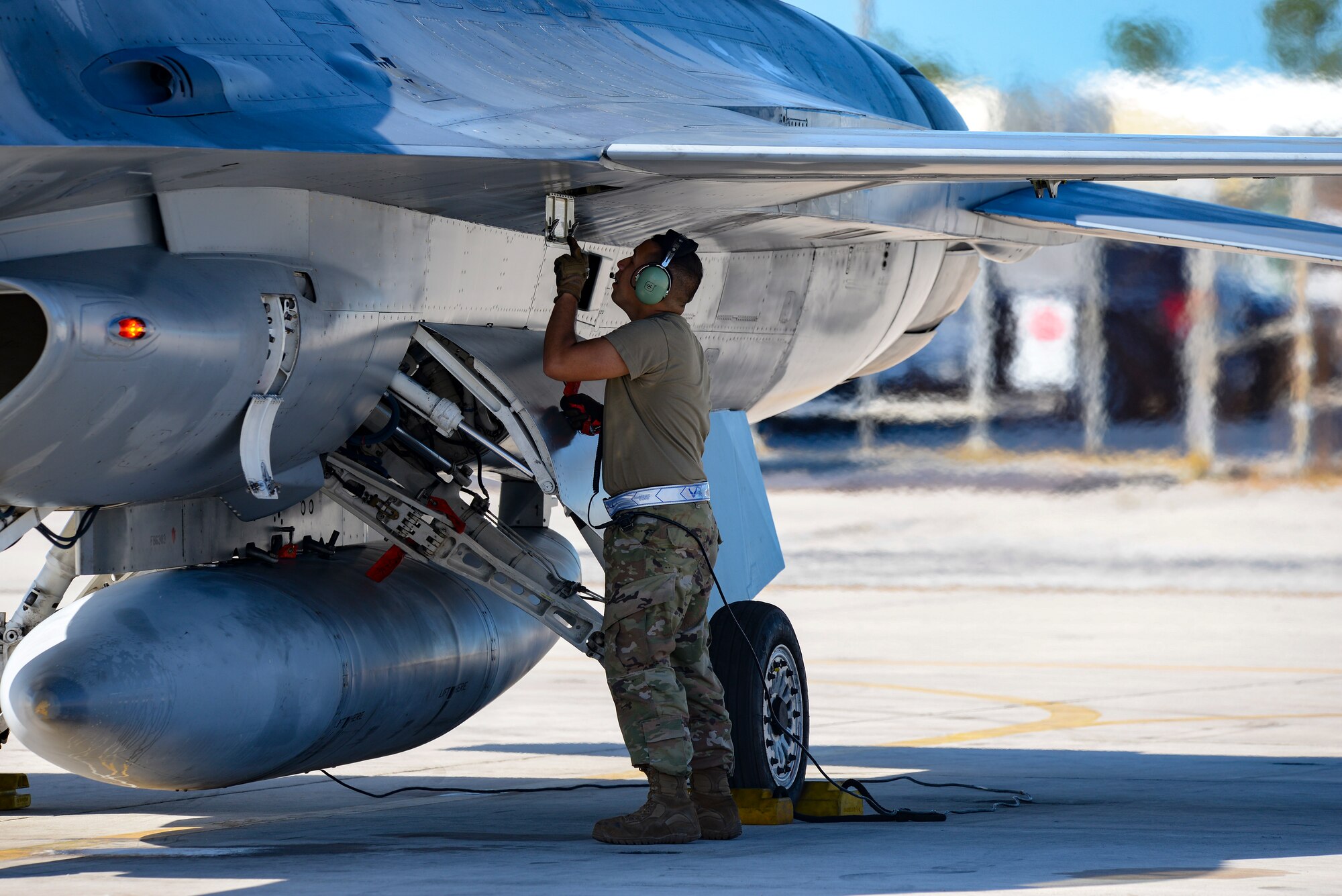 Image of F-16 Fighting Falcon crew chief conducting pre-launch procedures