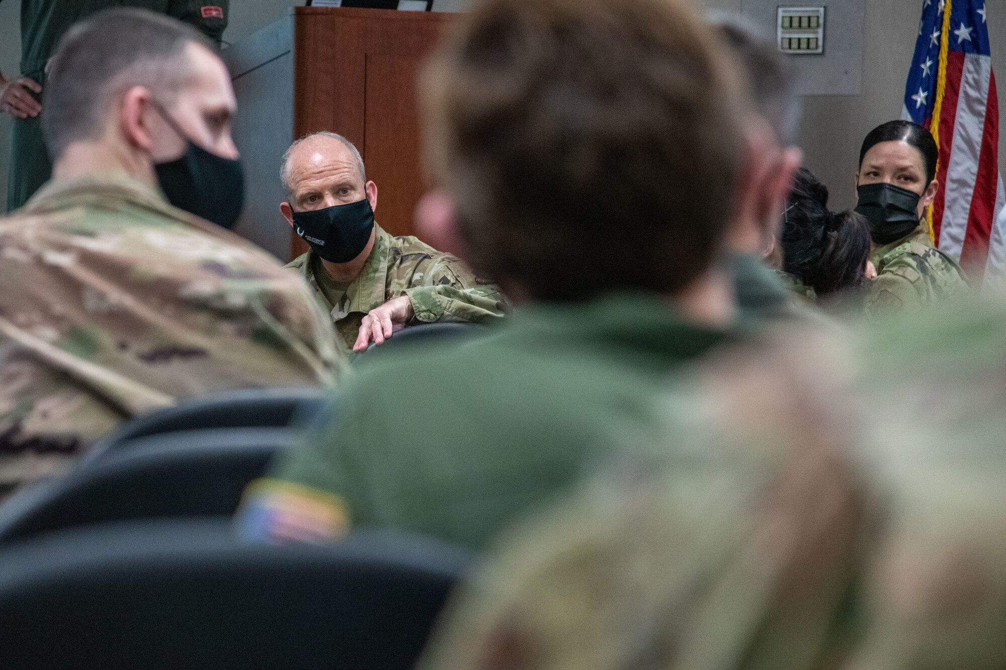 Two Airmen turn around to listen to others in the foreground