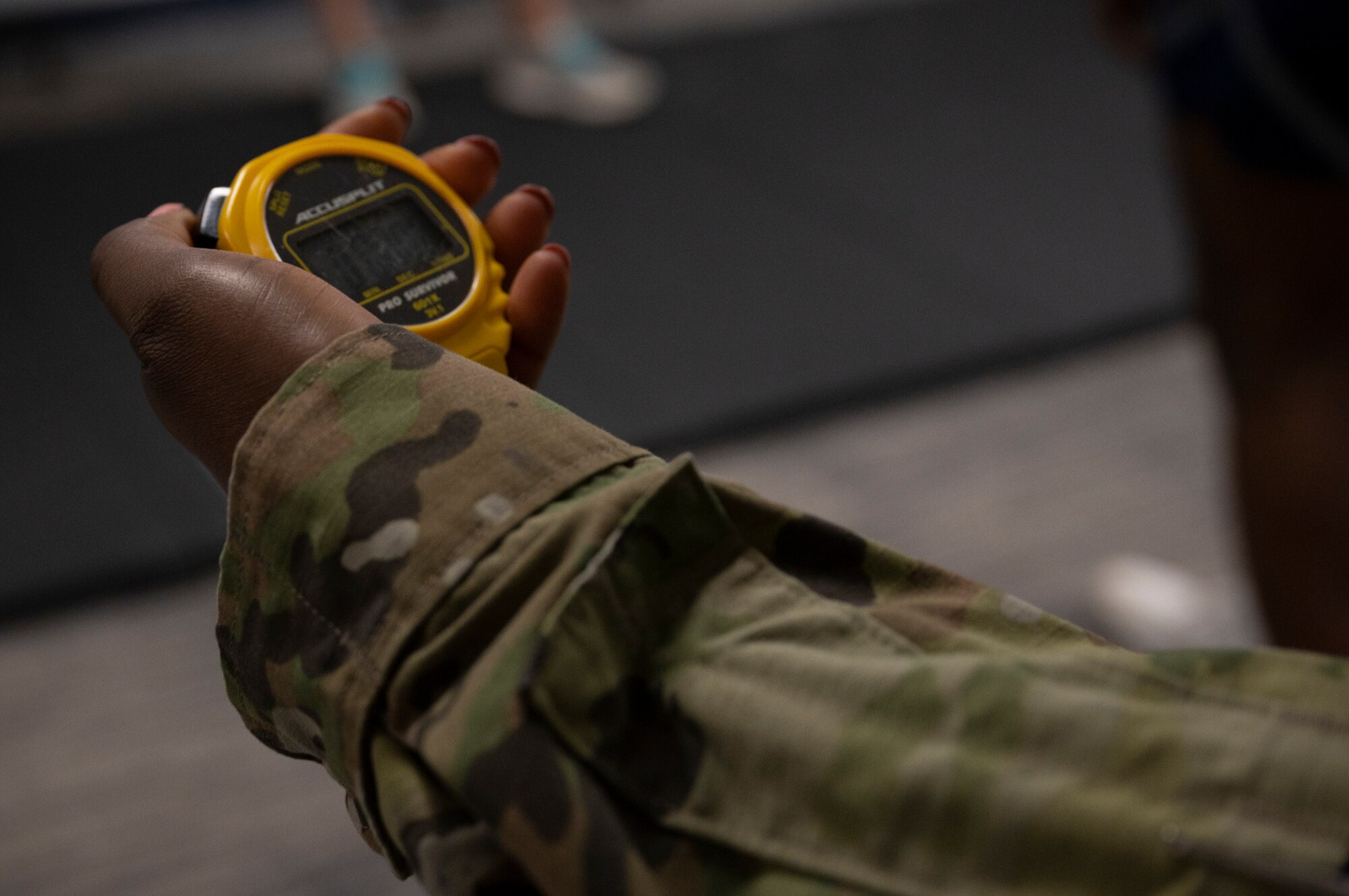 U.S. Air Force Senior Airman Diana Fareed, a pay technician with the 315th Airlift Wing at Joint Base Charleston, S.C., times the upper body strength portion of a physical fitness assessment here, Feb. 6, 2022. Fitness assessments officially resumed this month after delays due to COVID-19. (U.S. Air Force photo by Staff Sgt. Haley D. Phillips)