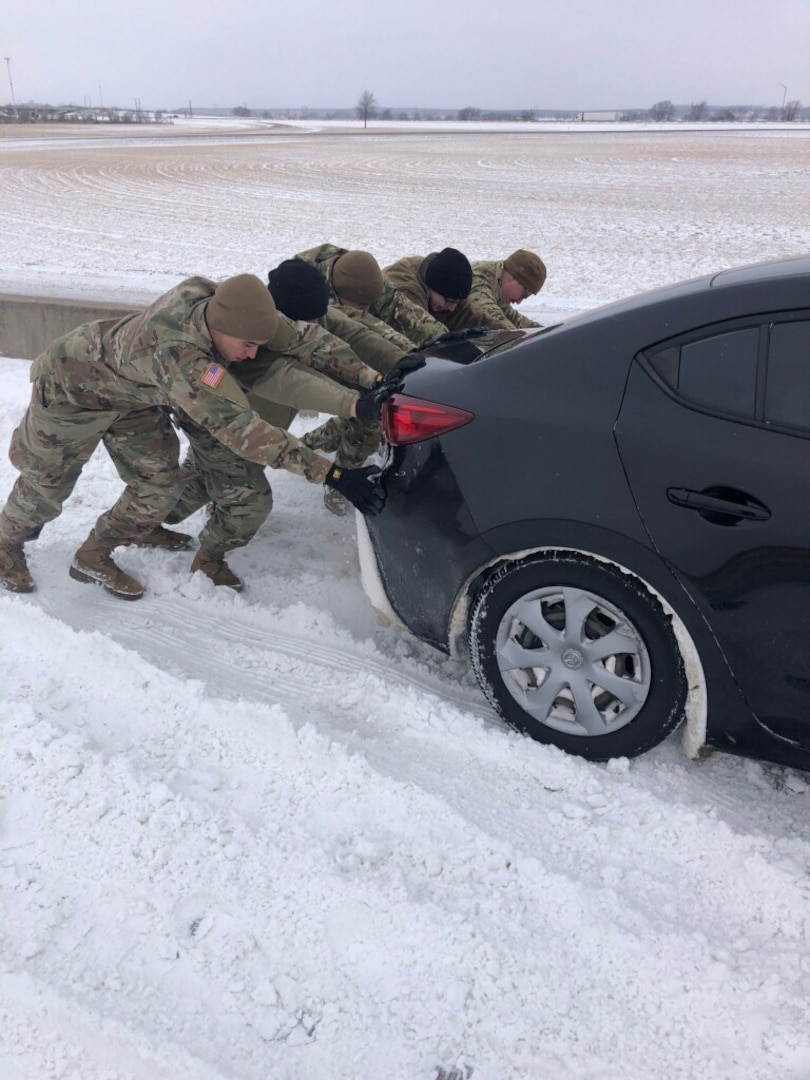 Oklahoma National Guard members push a vehicle out of a snowbank on the Will Rogers Turnpike near Vinita, Oklahoma, Feb. 3, 2022. About 40 Guard members worked with the Oklahoma Highway Patrol to assist stranded motorists in a winter storm.