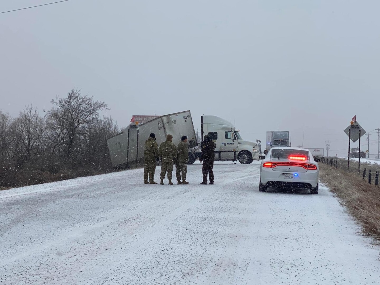 Oklahoma National Guard members help Oklahoma Highway Patrol officers prevent a semi-truck from rolling over during recovery operations in Calera, Oklahoma, Feb. 3, 2022.