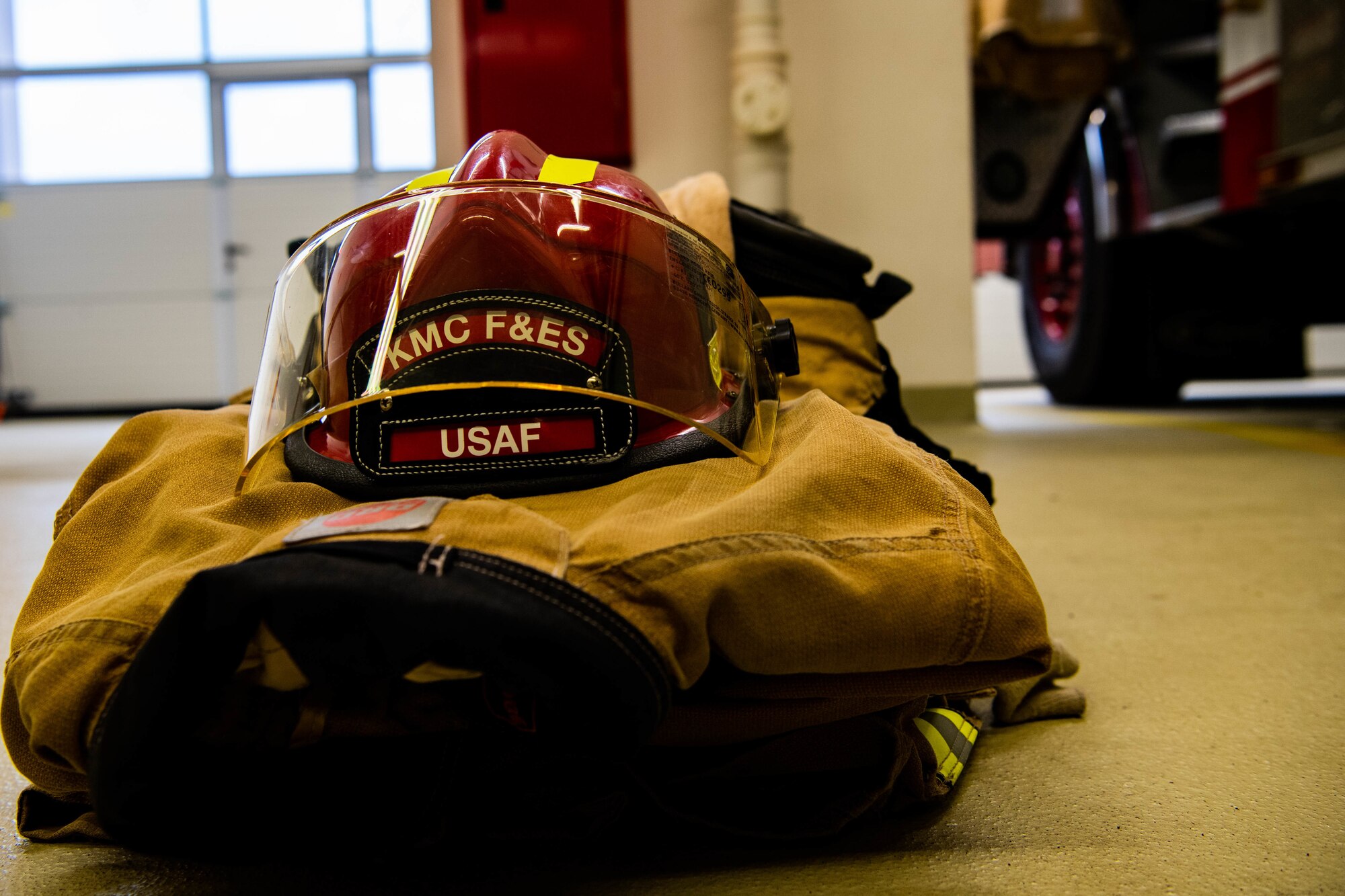 Fire gear sits near a fire truck.
