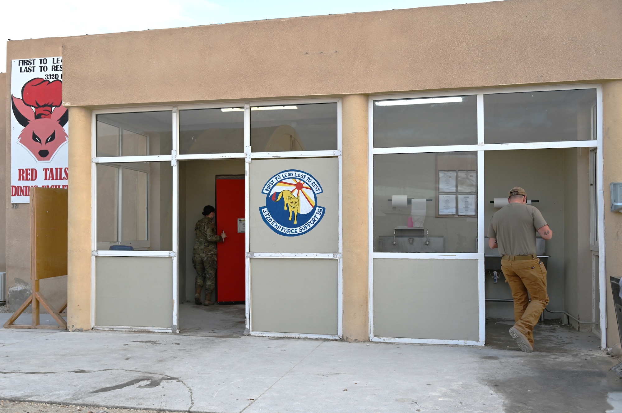 332d Air Expeditionary Wing Airmen enter the Red Tails Dining Facility Feb., 7, 2022 in Southwest Asia. The 332d Expeditionary Force Support Squadron, in conjunction with the 332d Expeditionary Civil Engineer Squadron, just completed its dining facility multifaceted renovation project. (U.S Air Force photo by Tech. Sgt. Lauren M. Snyder)