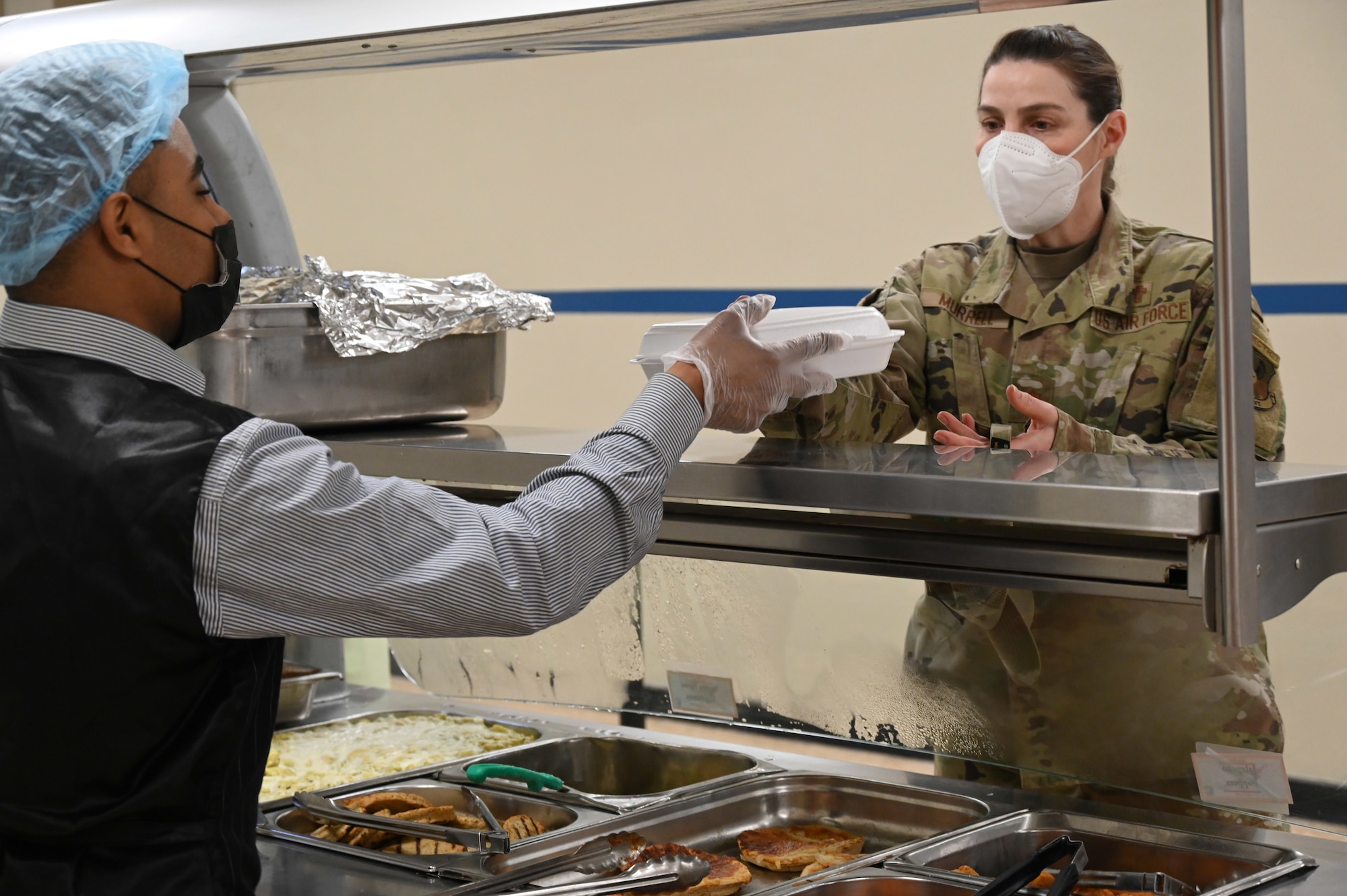 U.S. Air Force Maj. Amber Murrell, 332d Air Expeditionary Wing chaplain, receives her hot breakfast in the Red Tails Dining Facility Feb., 7, 2022 in Southwest Asia. The 332d Expeditionary Force Support Squadron, in conjunction with the 332d Expeditionary Civil Engineer Squadron, just completed its dining facility multifaceted renovation project. (U.S Air Force photo by Tech. Sgt. Lauren M. Snyder)