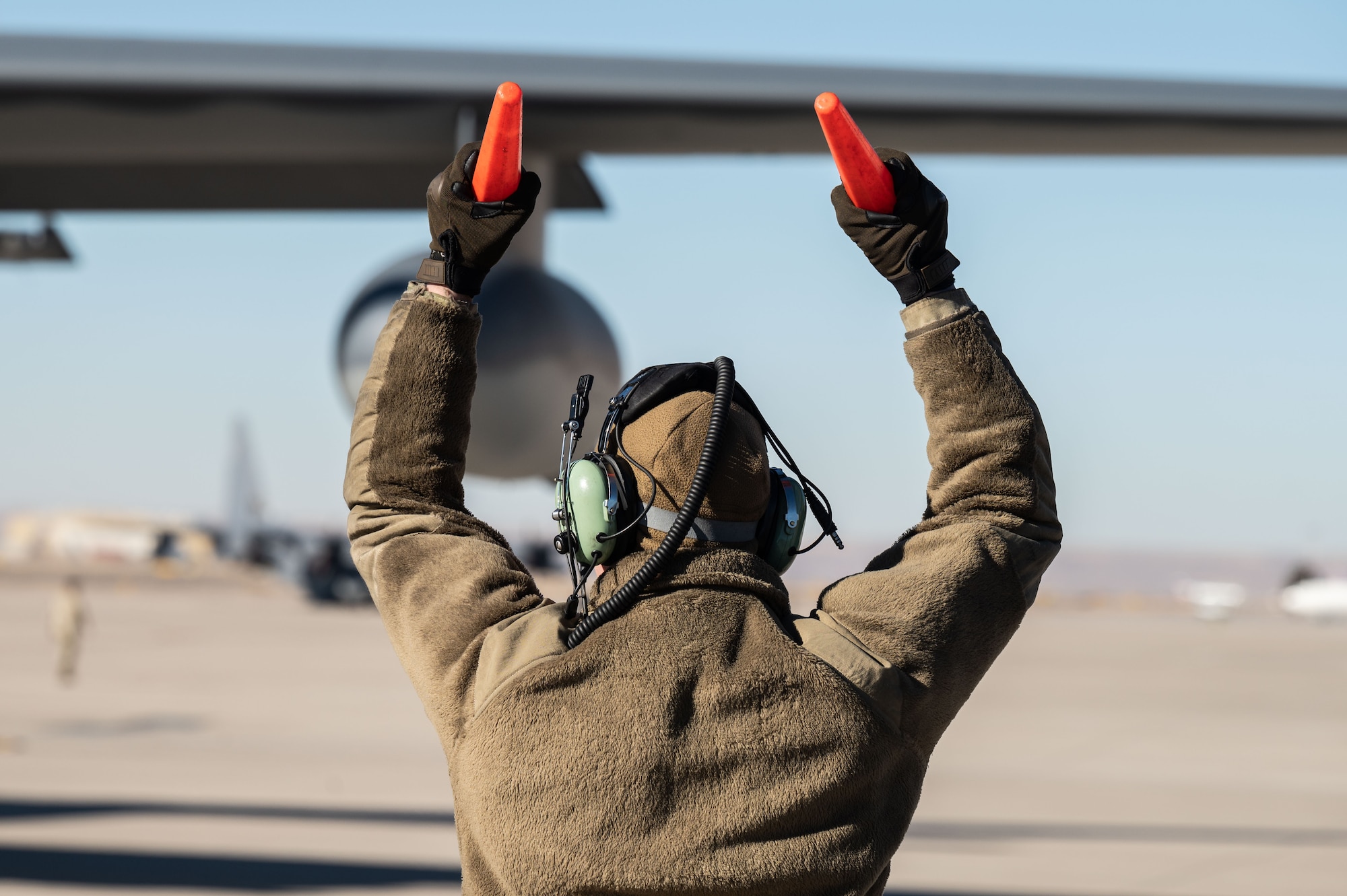 An Airman marshals a C-130.