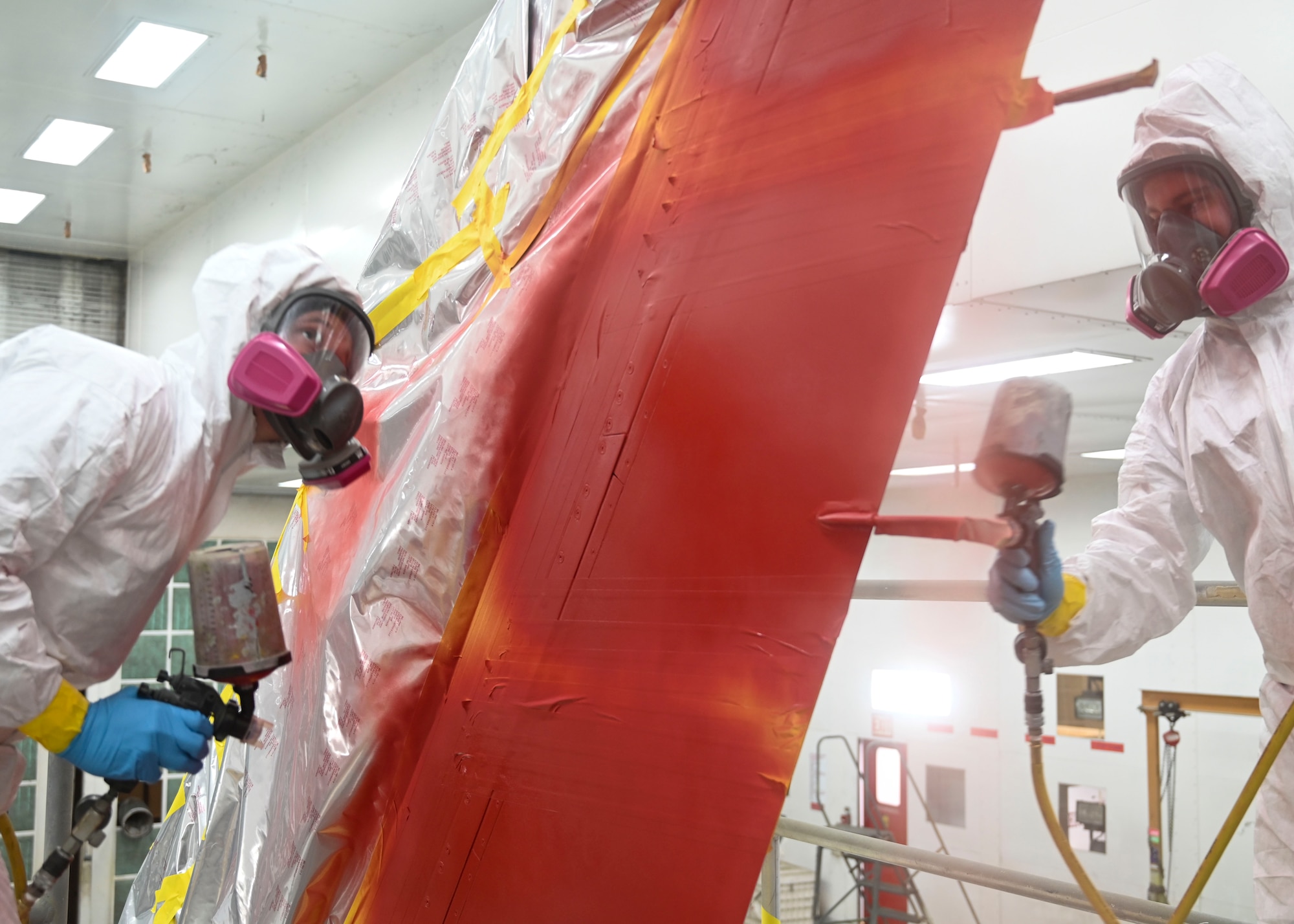 U.S. Air Force Staff Sgt. Jarred Crecraft, 56th Equipment Maintenance Squadron low observable aircraft structural maintenance craftsman, and Senior Airman Brandon Wright, 56th EMS low observable aircraft structural maintenance journeyman, paint the tail of an F-16 Fighting Falcon aircraft Jan. 13, 2022, at Luke Air Force Base, Arizona.