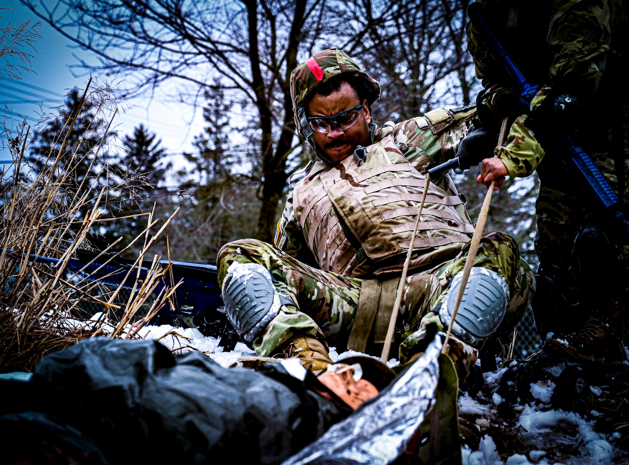 A U.S. Army Soldier, Army Support Activity Dix, pulls a demonstration human manikin on a lightweight foldable field stretcher at the Medical Simulation Training Center (MSTC) on Feb. 3, 2022, at Joint Base McGuire-Dix-Lakehurst, N.J. The MSTC provides state of the art training in treating all areas of trauma and basic medical scenarios. Under the principles of Tactical Casualty Combat Care (TC3), students gain knowledge and skills to treat severe bleeding, manage a tension pneumothorax, and establish a secure airway. The MSTC offers TC3 training through classroom instruction, basic hands-on training, and the use of realistic trauma and medical scenarios. The functional skills developed are supported and reinforced by a final simulated battlefield exercise. This immersive environment helps to familiarize the student with potential environments found in deployed environments.