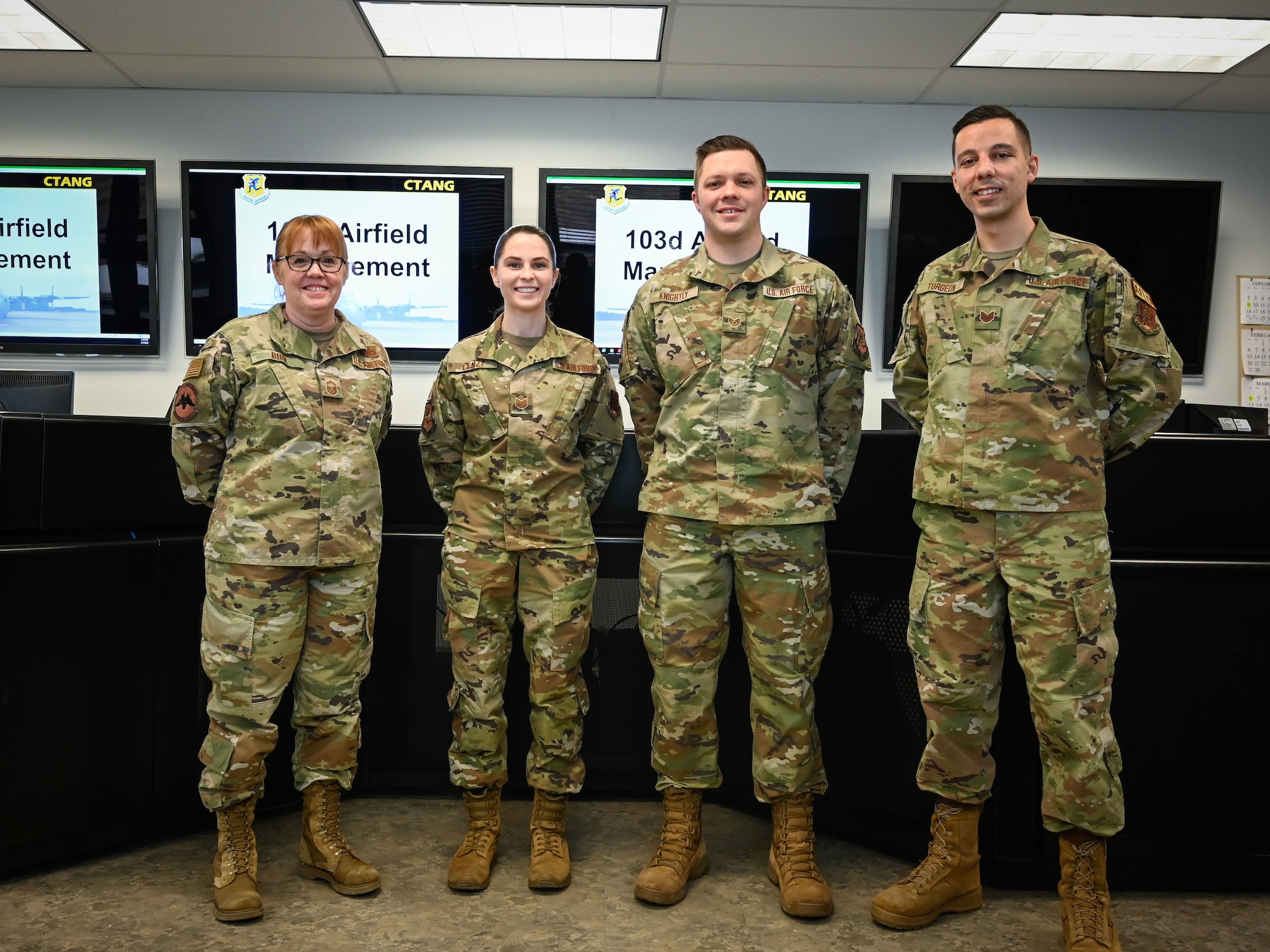 U.S. Air Force Senior Master Sgt. Winnie Dion, left, Tech. Sgt. Jennifer Lenzi, Staff Sgt. Jordan Knightly, and Tech. Sgt. Robert Turgeon, 103d Operations Support Squadron airfield management team, at the operations desk at Bradley Air National Guard Base in East Granby, Conn., Feb. 7, 2022. The airfield management team was named Ronald B. McCarthy Airfield Management Facility of the Year as part of the Air National Guard’s 2021 Airfield Management Operations Awards, and Dion and Lenzi were named Airfield Management Senior Noncommissioned Officer of the Year and Noncommissioned Officer of the Year, respectively. (U.S. Air National Guard photo by 2nd Lt. Steven Tucker)