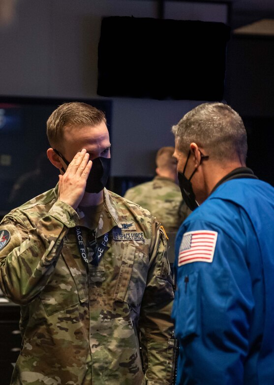 U.S. Space Force Col. Mike S. Hopkins, NASA astronaut, salutes U.S. Space Force 1st Lt. Alexander Colla, Space Delta 8 – Satellite Communications and Navigational Warfare, 4th Space Operations Squadron crew commander, after receiving a briefing on the 4th SOPS mission at Schriever Space Force Base, Colorado, Jan. 27, 2022. 4th SOPS operates the U.S. Space Force's protected and wideband Military Satellite. Communications systems. (U.S. Space Force photo illustration by Tiana Williams)