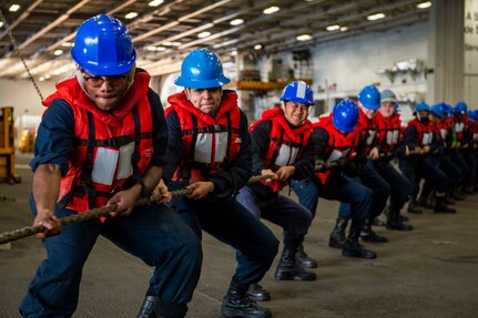 Sailors assigned to the aircraft carrier USS George H.W. Bush (CVN 77) heave a line during an ammunition onload with the dry cargo and ammunition ship USNS Medgar Evers (T-AKE 13), Feb. 3, 2022.