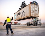 A Coalition civilian contractor directs the movement of equipment sent from locations in Iraq, to Camp Arifjan, Kuwait, Jan. 19, 2022. The equipment was received as part of a strategic effort to recycle and reapportion unused equipment as Combined Joint Task Force – Operation Inherent Resolve continues its advise, assist, and enable mission. (U.S. Air National Guard photo by Staff Sgt. Chloe Ochs)